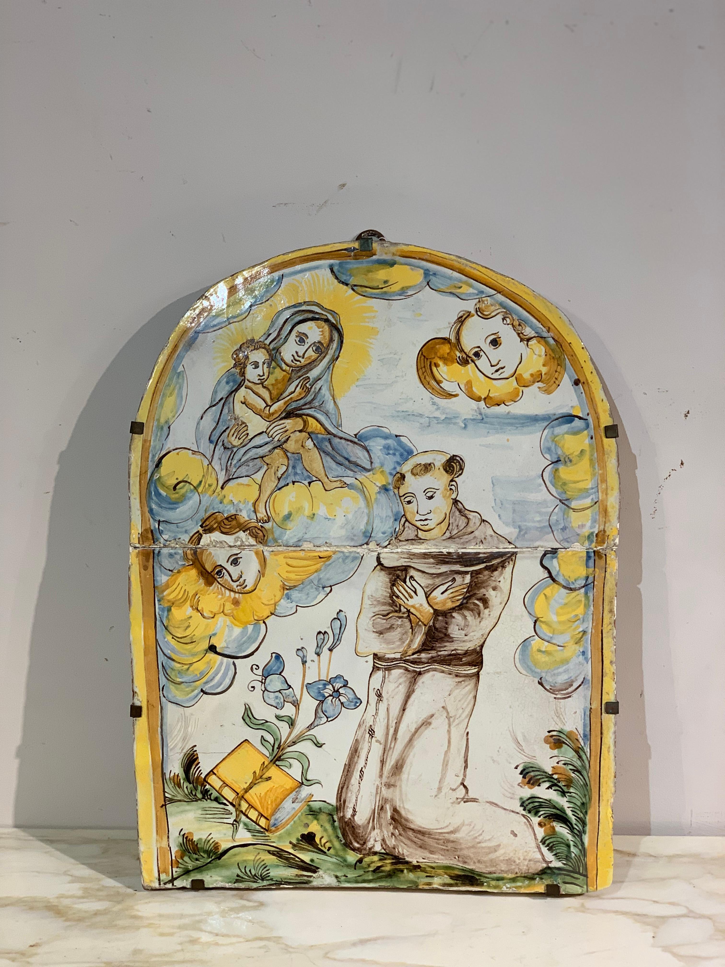 Belle plaque de tabernacle en majolique polychrome, représentant la Vierge à l'enfant et Saint Antoine de Padoue. Le dessin et les couleurs rappellent les premières majoliques polychromes des célèbres fours de Montelupo Fiorentino. Le cadre est