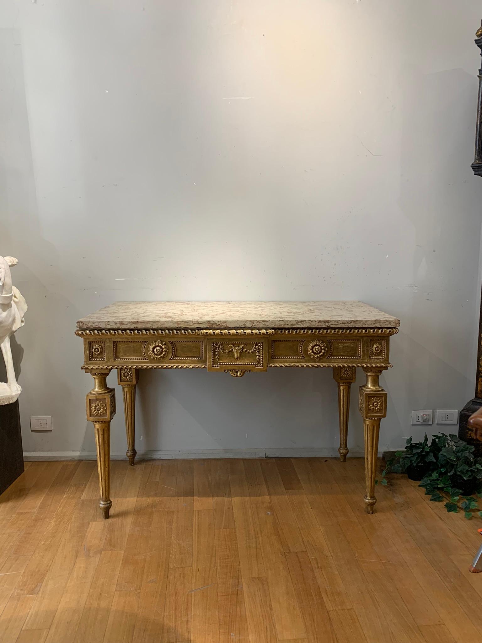 Stunning wall console in carved wood gilded with pure gold leaf, of Emilian manufacture from the end of the 18th century. It is an example of high manufacturing, characterized by detailed and refined craftsmanship. The carved wood features refined