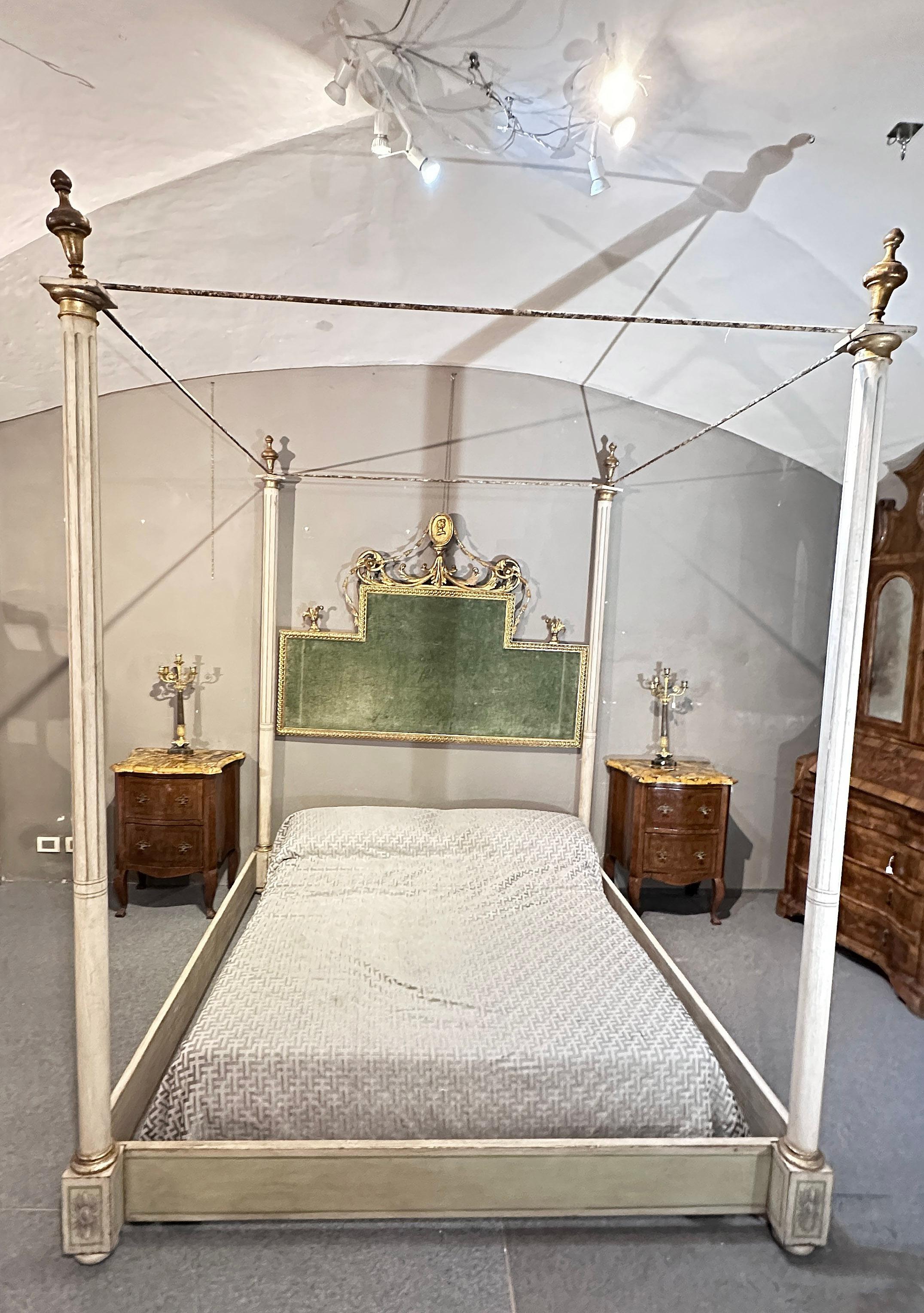 Beautiful and refined canopy bed in painted wood, double size. Featuring linear and floral painted decorations at the bottom, the canopy supports consist of columns with gold trim and gold pine cone tips. The headboard of the bed is embellished with