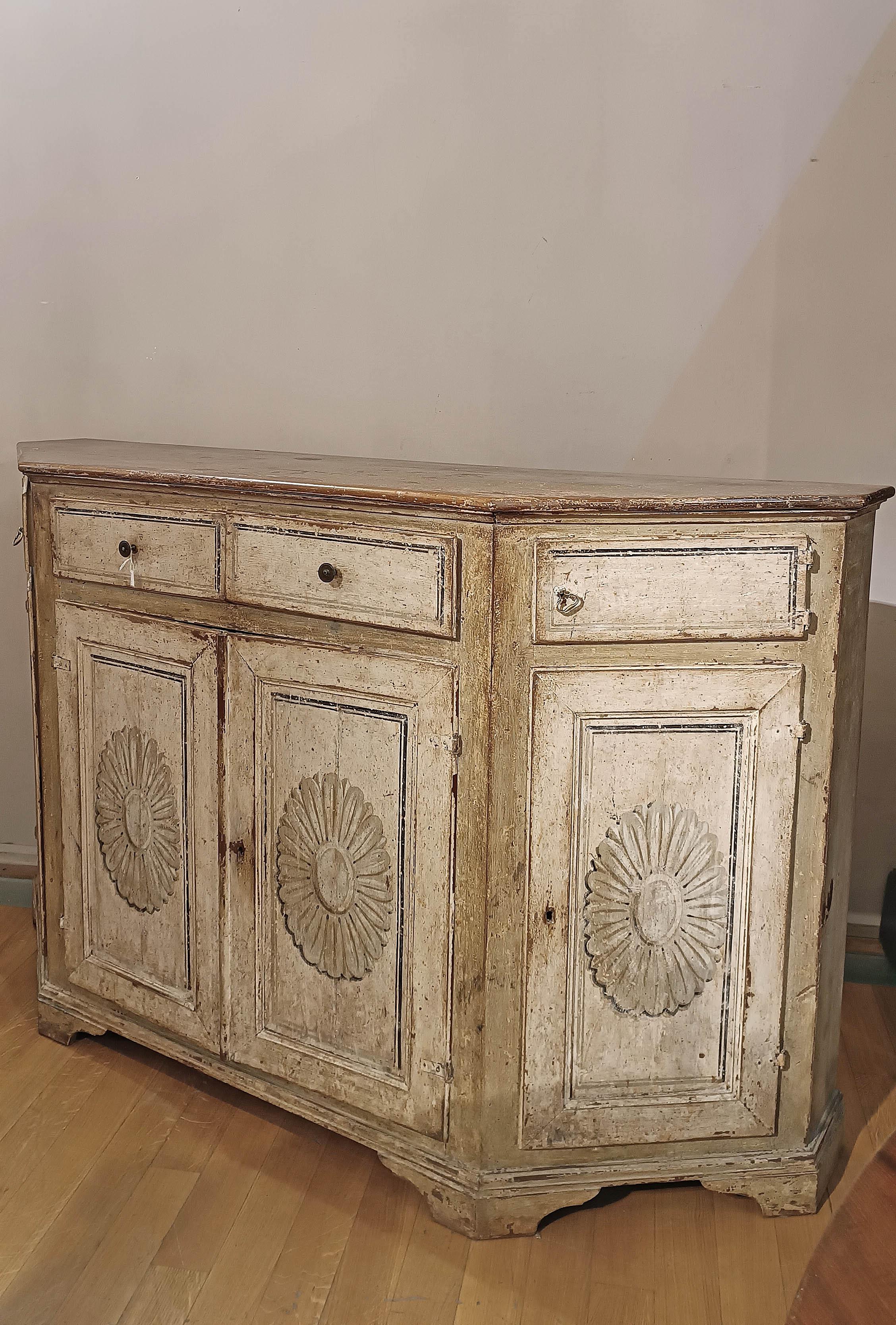 Beautiful neoclassical sideboard in solid wood painted with gray colors and decorations typical of the Louis XVI period. The shelf feet also give it a timeless elegance. On the upper part the sideboard has two drawers and two doors, the latter along