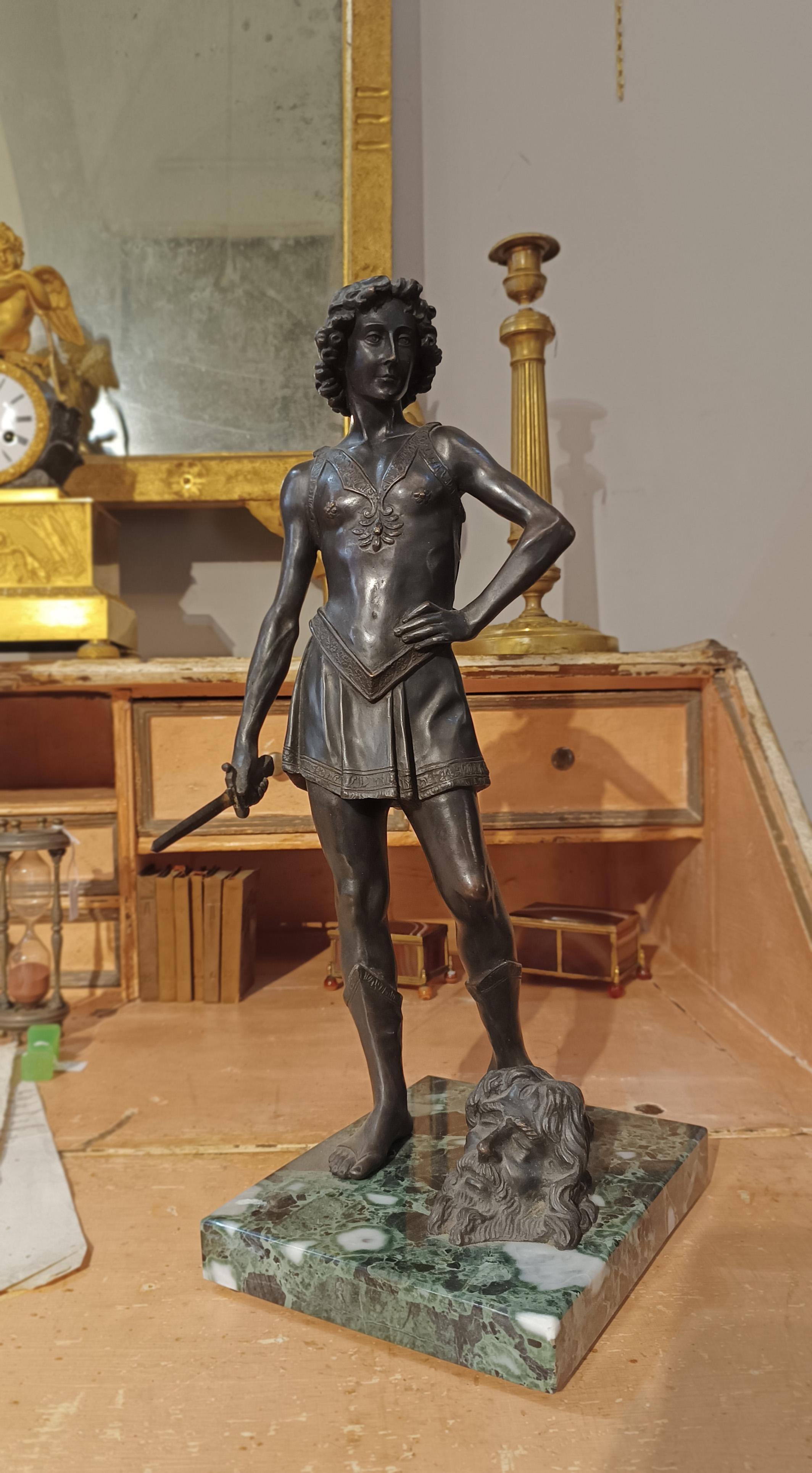 Belle sculpture en bronze coulée selon la technique de la cire perdue, représentant le jeune David debout, l'épée levée, symbole de sa victoire sur le géant Goliath, dont la tête souffrante est représentée sur le socle en marbre vert. Avec une