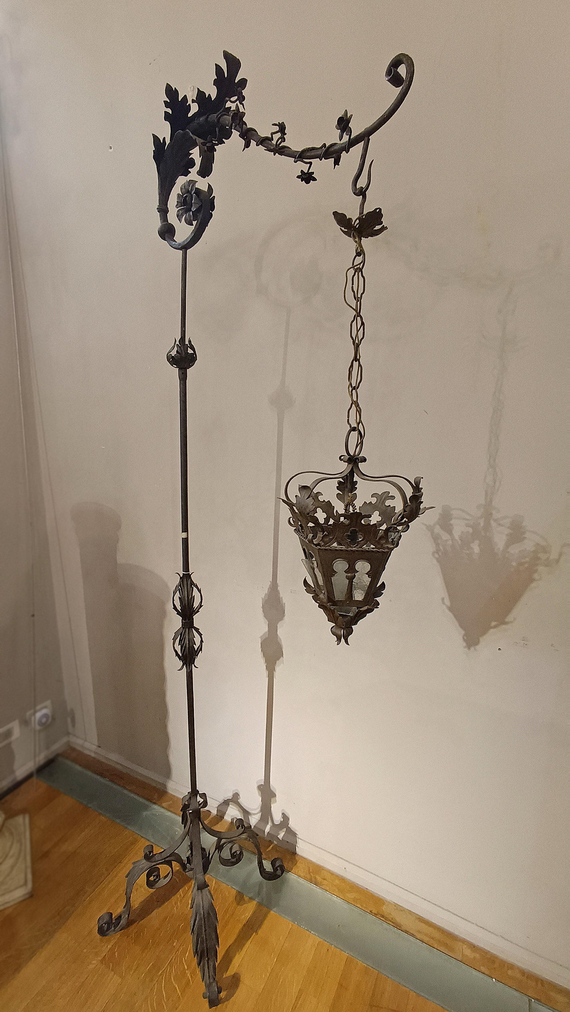 Characteristic and elegant hand-forged iron lantern holder. Its structure allows you to raise or lower the lantern as needed. The arm is rotatable, decorated with splendid vegetal racemes and supports the lantern, also decorated with vegetal details