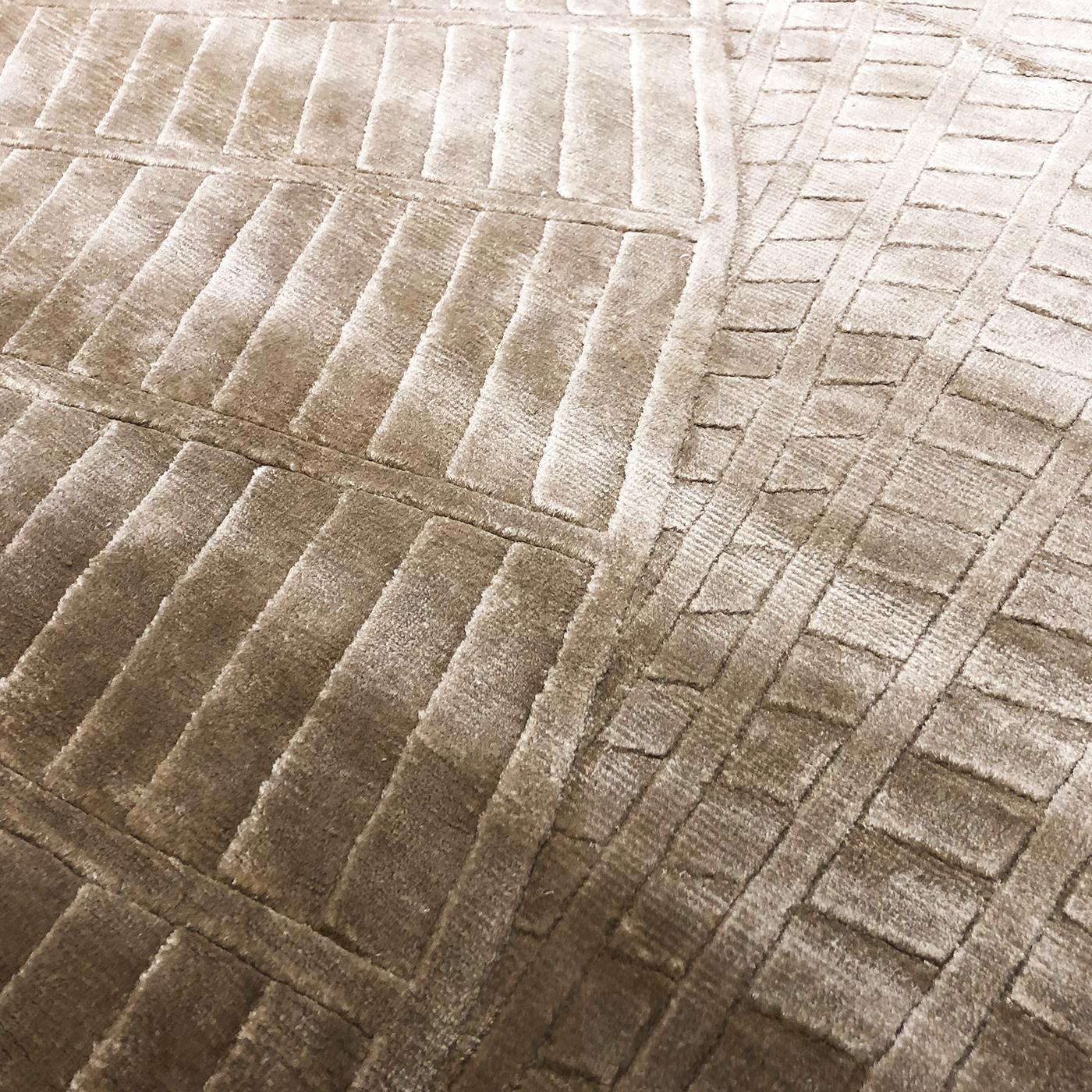 Als beiges Gegenstück zum Endless Rug in seiner blauen Variante bietet dieser raffinierte Teppich eine sanftere Perspektive der optischen Kunst, die sich auf seinen strukturellen Reiz stützt. Nepalesische Handwerksmeister schießen dieses Bodendekor