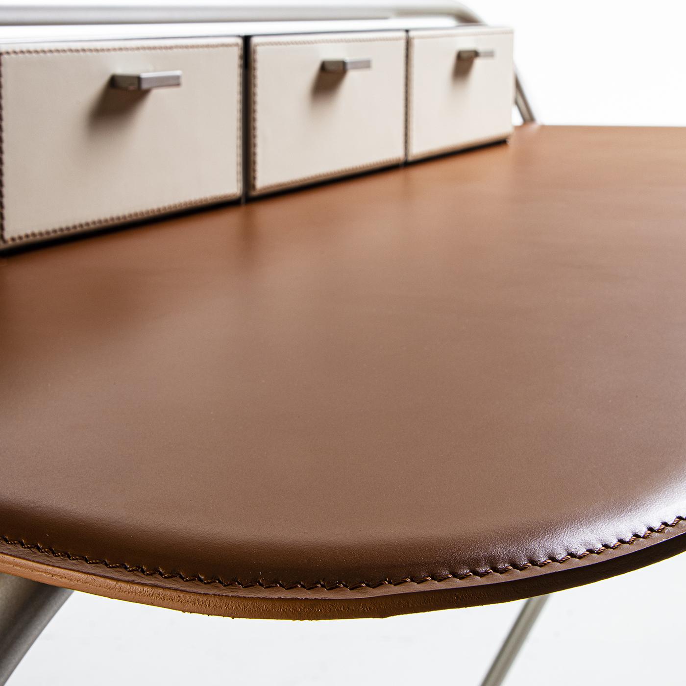 In line with Studio Nove.3 style, Enea is an essential desk where metal and hard leather are combined in the most refined way. Made of a tubular metal frame lacquered in different finishes, including gold, champagne, and bronze. It has a cowhide top