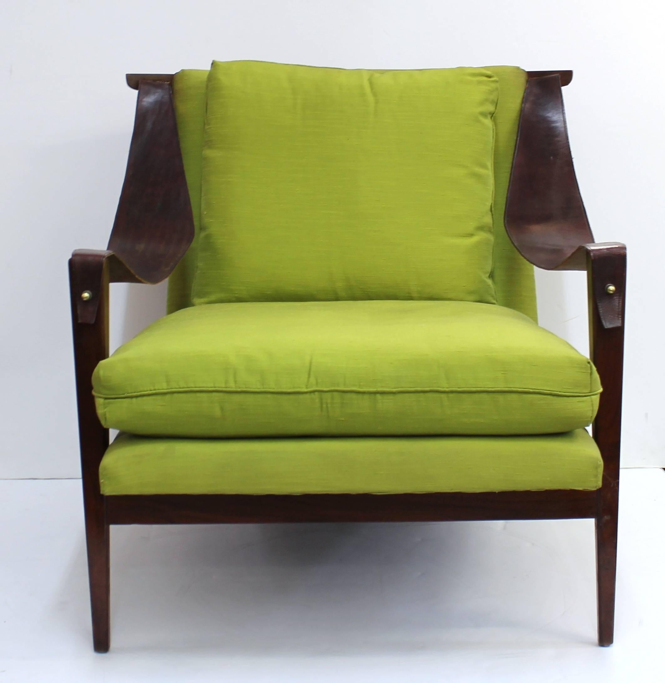 Enfield armchairs with leather swing arms. The chairs are upholstered in bright green fabric and feature solid dark wood frames on tessellated legs. Some visible wear including cracking to leather, arms becoming un-fixed and small chips to wood