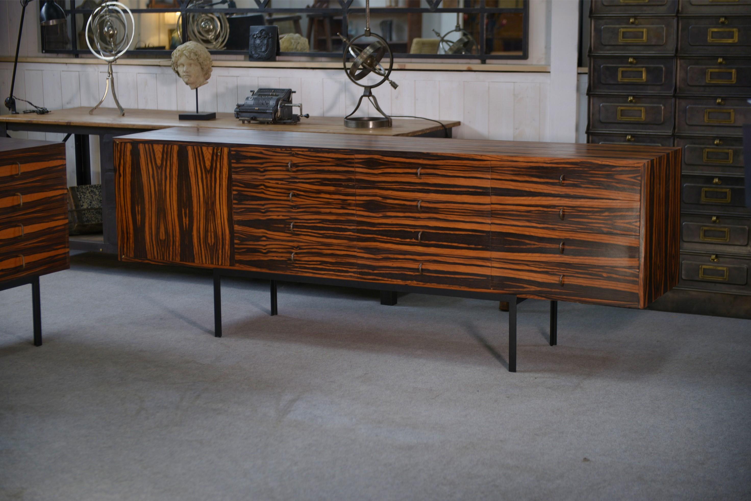 Enfilade design en ébène du Gabon 1 porte 12 tiroirs 1960's

Pièce maîtresse, rara per il suo formato e la sua essenza preziosa. La facciata mostra uno spettacolare placage d'ébène du Gabon au veinage graphique, assemblato in bookmatch per un