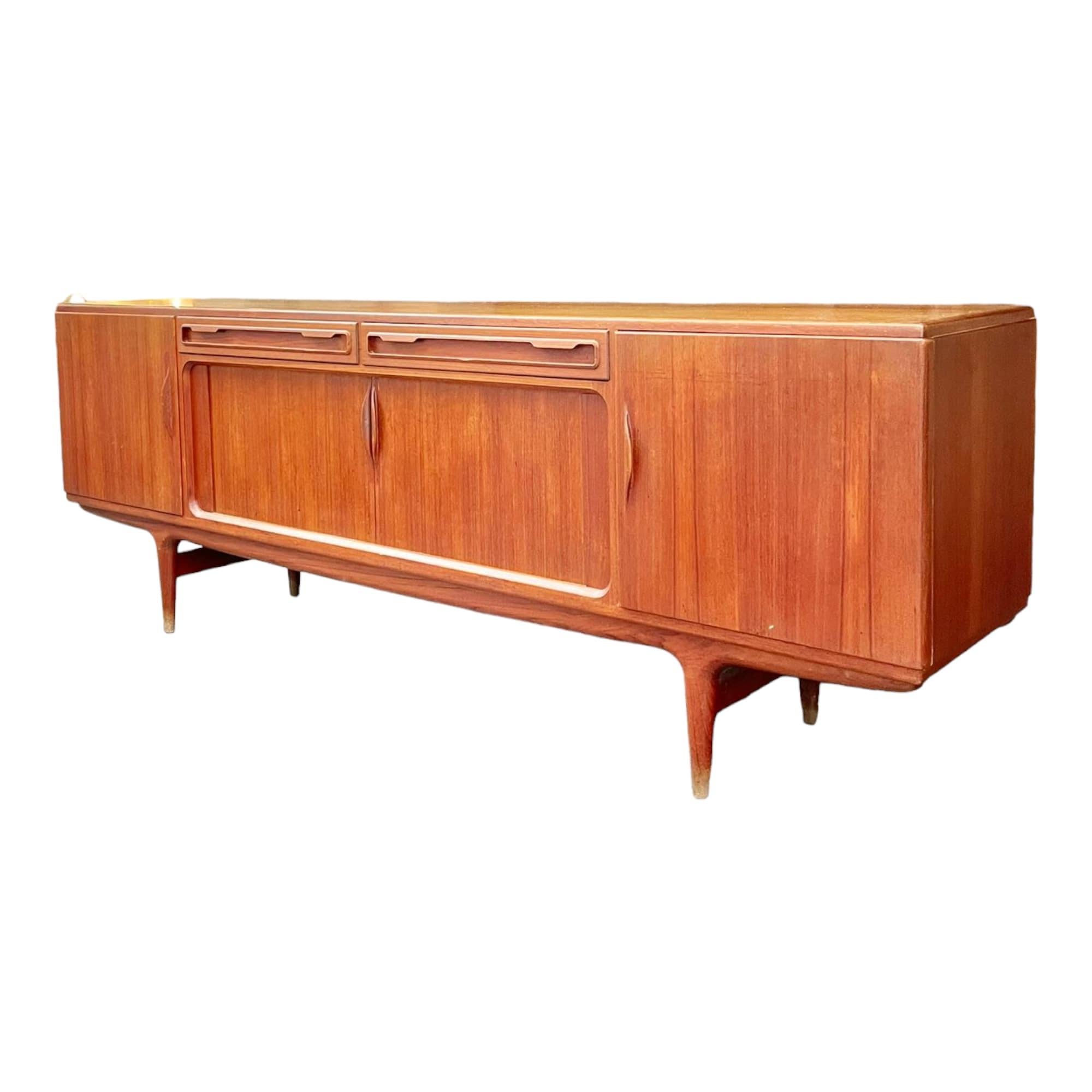 From Denmark. Discover the timeless elegance of Danish design with this stunning 1960s teak sideboard, designed by the famous Johannes Andersen for Møbelfabrik.

Featuring sliding doors and drawers, this piece seamlessly combines functionality and