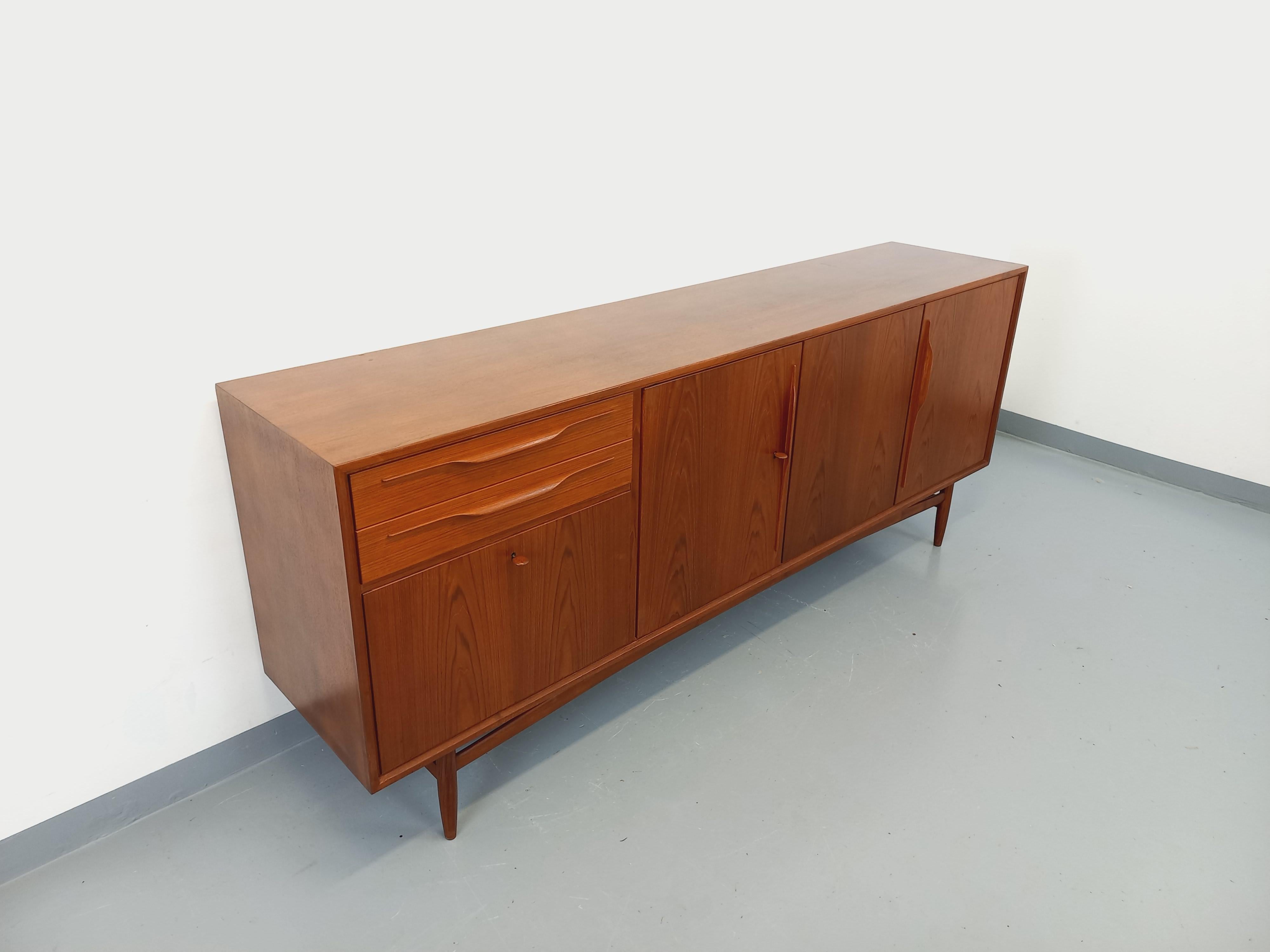 Enfilade basse vintage style scandinave des années 60, en teck, de marque Swiss Teak, magnifiques poignées tout en courbes et finesse, très beau piètement aérien avec pieds compas, 2 superbes clés en teck, belles finitions soignées des angles,