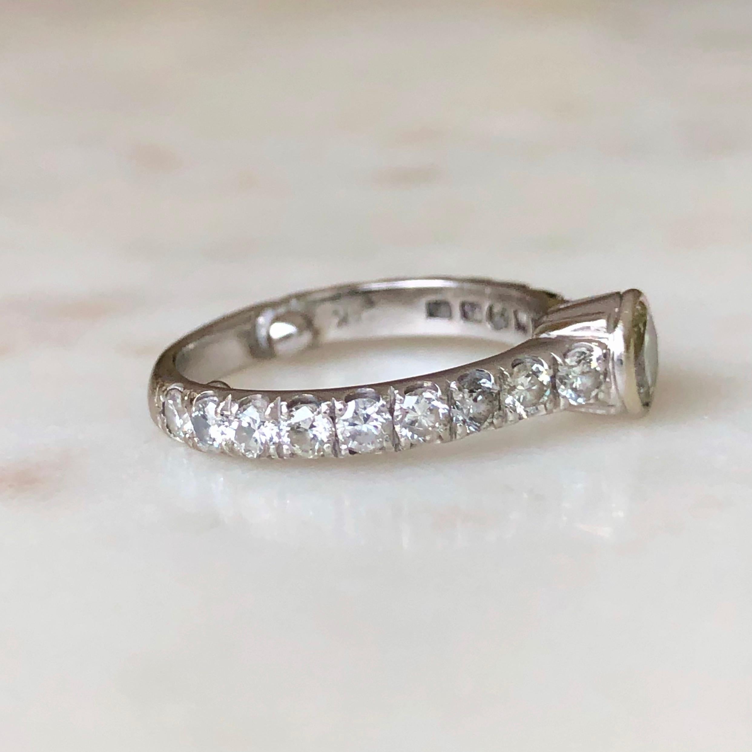 Engagement solitaire ring with diamond accents; excellent condition.
White gold  bezel set center round brilliant cut diamond 4.4mm 0.36 carat J-SI1. Set on the side of the band with eighteen (18) natural diamonds, round brilliant cut, set in shared