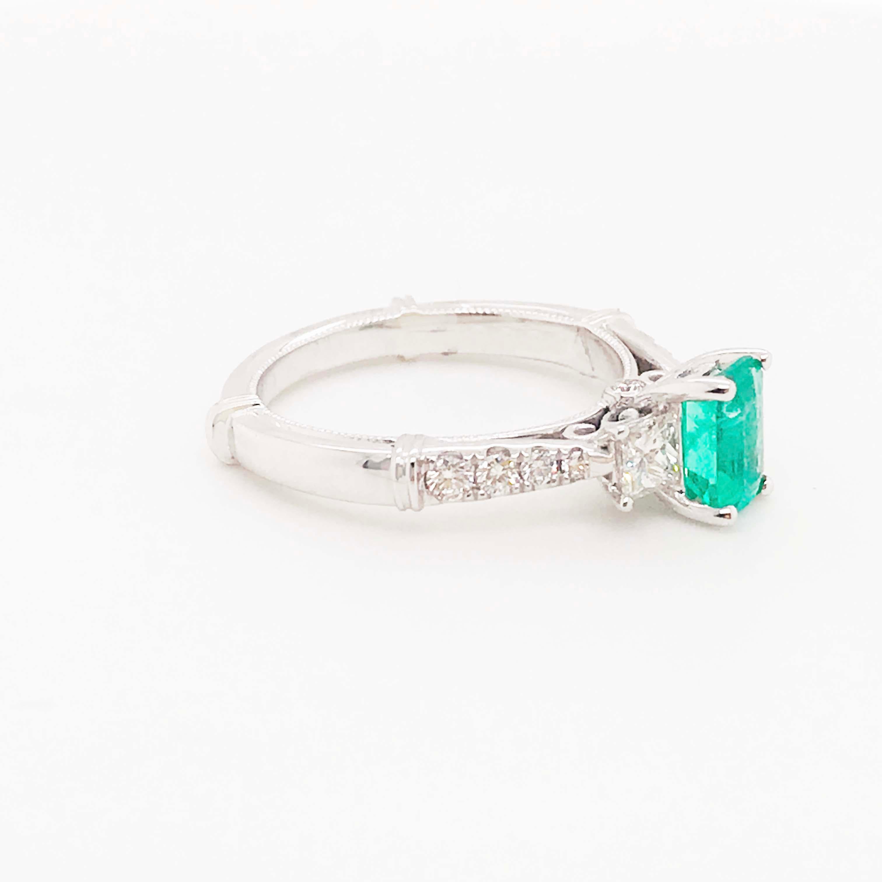This genuine emerald gemstone has been cut in an emerald shape and exactly .92 carats to show off the vivid and bright green color with a hint of bluish!  Set in 18 karat white gold, this ring has two accent diamonds making this design a modern
