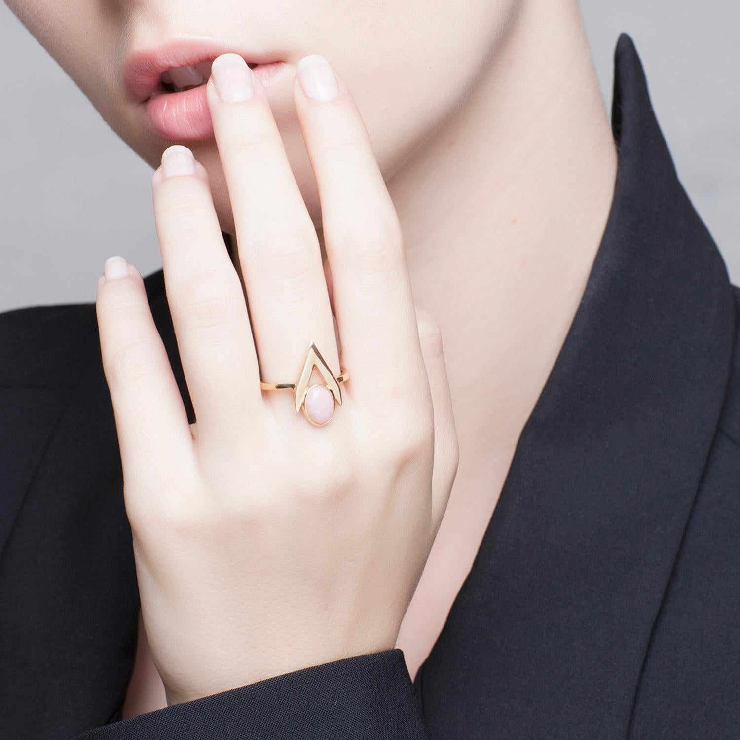 Add jewellery with a modern, feminine attitude to your outfit with this 9 Karat gold ring from Iosselliani.  Crafted in Italy in 9 Karat gold, the ring features a pink opal cabochon framed into a V shape. Stone size 8x6 mm. Central height: 1,8 cm,