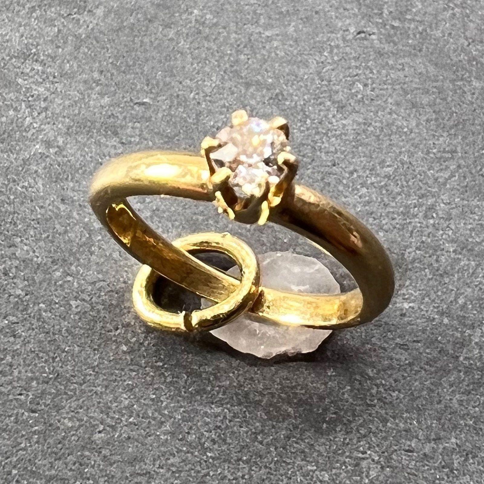 A 14 karat (14K) yellow gold charm pendant designed as an engagement ring set with a solitaire old cut white diamond weighing approximately 0.03 carats. Unmarked but tested for 14 karat gold.

Dimensions: 1.2 x 1 x 0.25 cm (not including jump