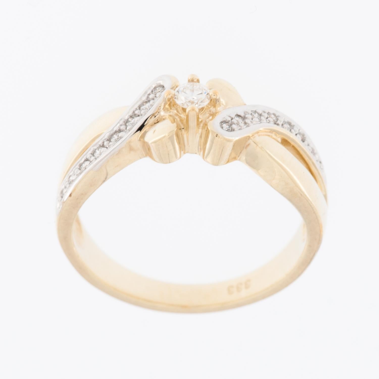 This engagement ring crafted in 8 karat gold and adorned with exquisite diamonds is a symbol of timeless elegance and commitment. The band, made from lustrous 8 karat gold, adds a warm and rich hue to the piece, providing a classic and enduring