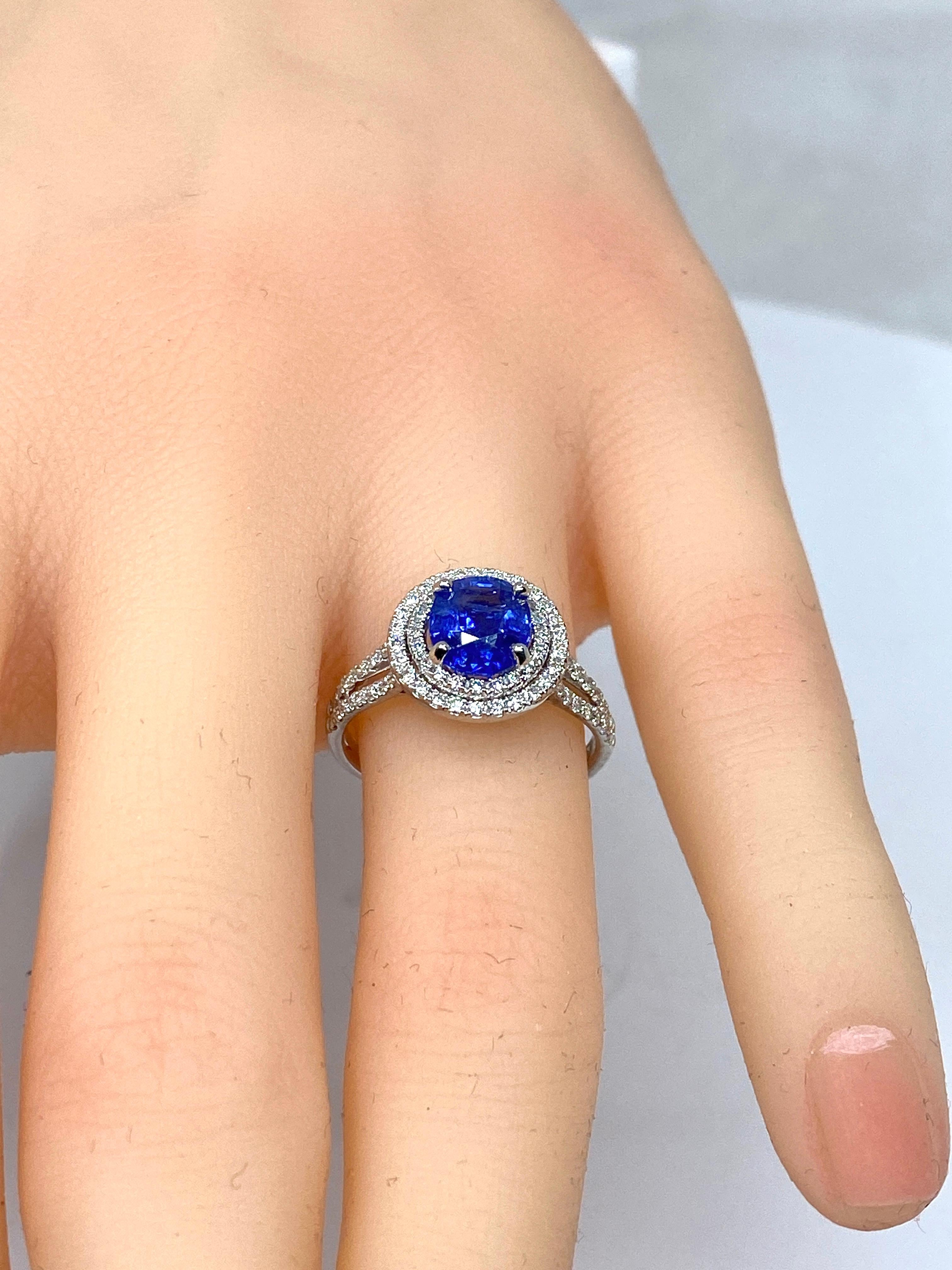 Ravissante bague de fiançailles en or 18 carats ornée au centre d’un saphir d’une très belle couleur bleue roi pesant : 1.56 carat, dans un double entourage de diamants de taille brillant de couleur G extra blanc. L’anneau est également serti de