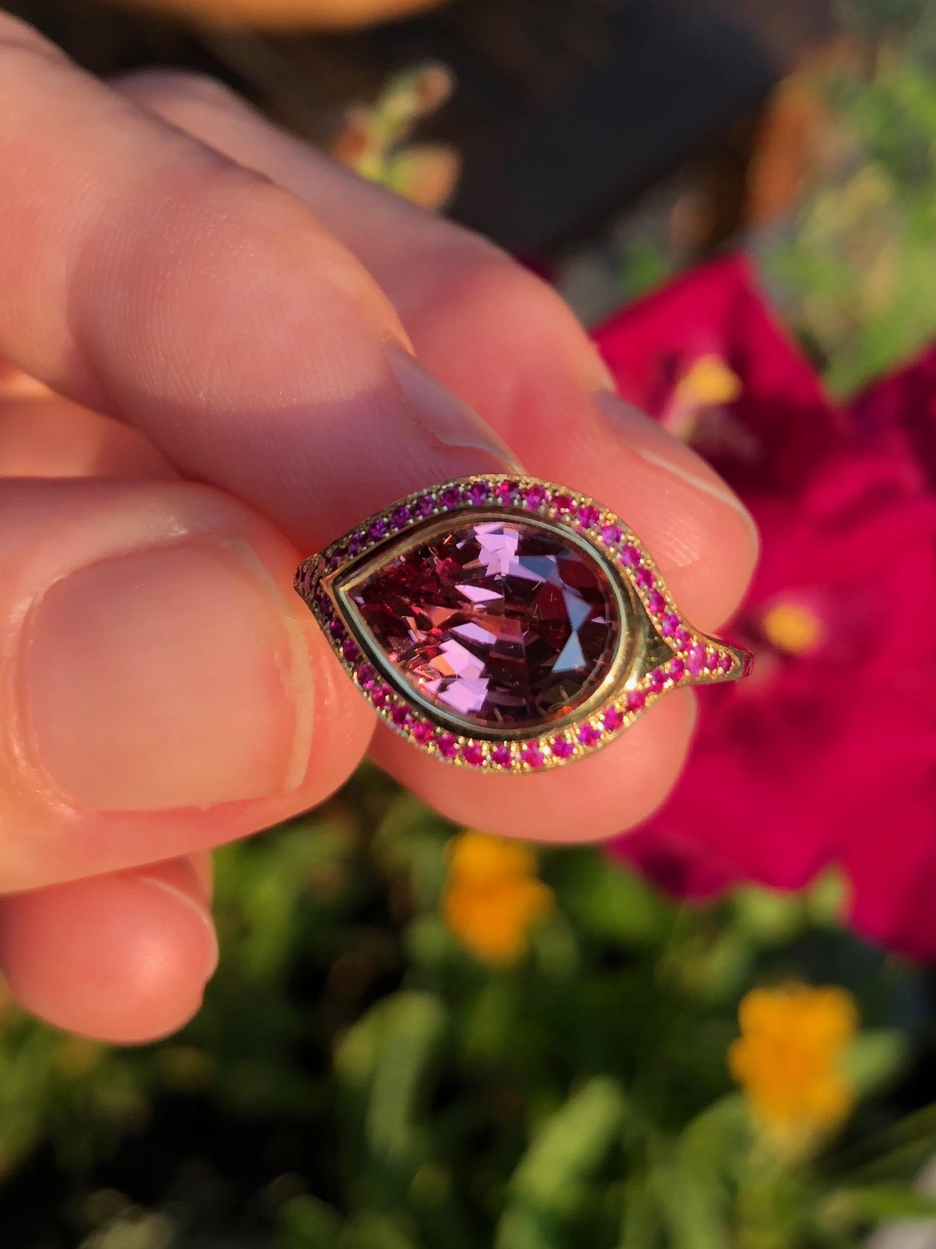 A stunning Mahenge Malaya Garnet (4.07 carats 11.5x8.5x5.7mm)- from Tanzania, encircled with fine Mozambique Gemfields rubies. This ring gives and gives. One of a kind. Absolutely stunning in all light. A combination of old world techniques that