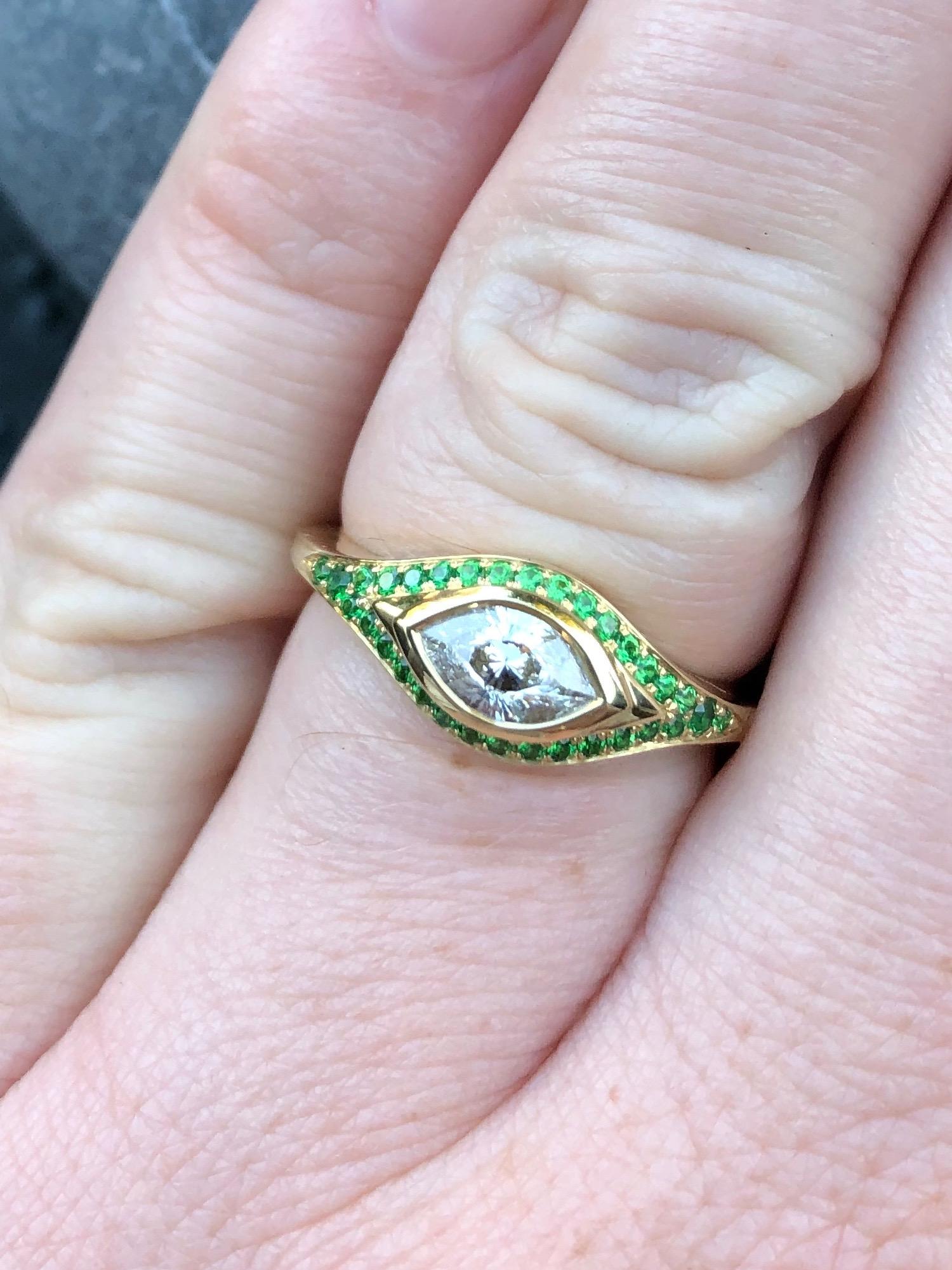 A singular Cleopatra's eye cut diamond (E/VS- 0.64 ct) with a tsavorite pavé. An engagement truly like no other, this diamond is absolutely fascinating. 
Hand carved wax/cast, made by hand start to finish by our master goldsmith.

Size 7.25 (can be