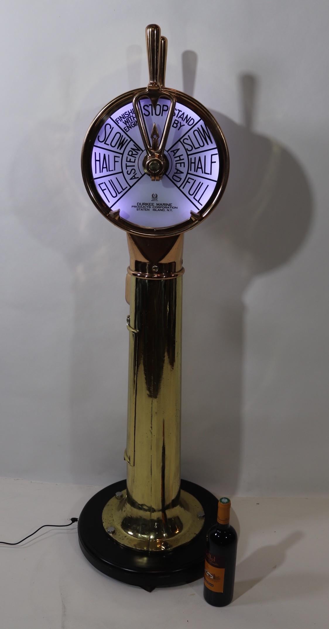 Solid brass ships engine order telegraph with faceplates from Durkee Marine Products Corporation of Staten Island New York. Faceplates by Lenox. Highly polished and lacquered, this unit gleams like solid gold. Fitted to a thick wood base with routed