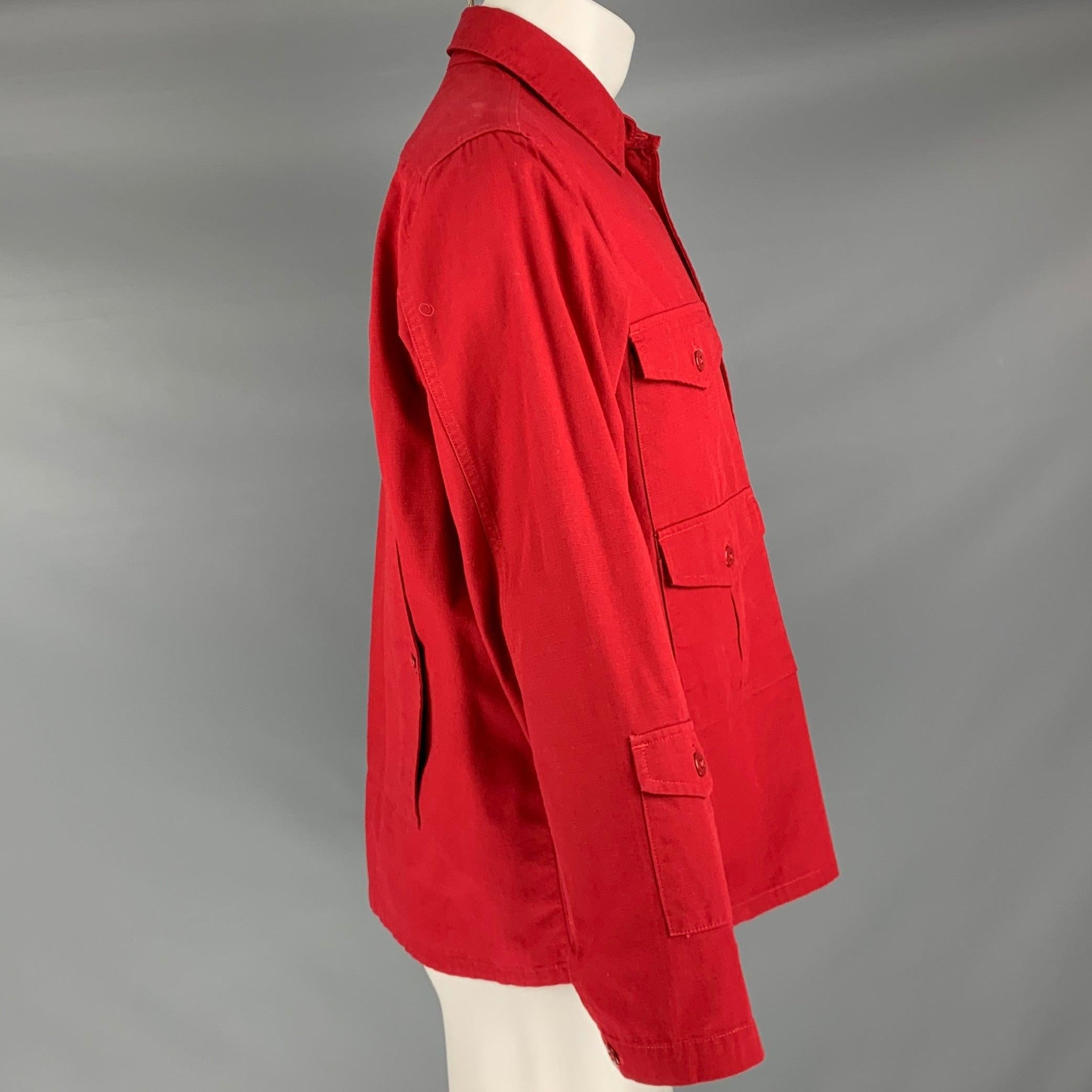 ENGINEERED GARMENTS jacket
in a red cotton woven fabric featuring a shirt jacket style, four patch pockets plus one large back pocket, and button closure. Made in USA.Very Good Pre-Owned Condition. Moderate signs of wear on back. 

Marked:   M