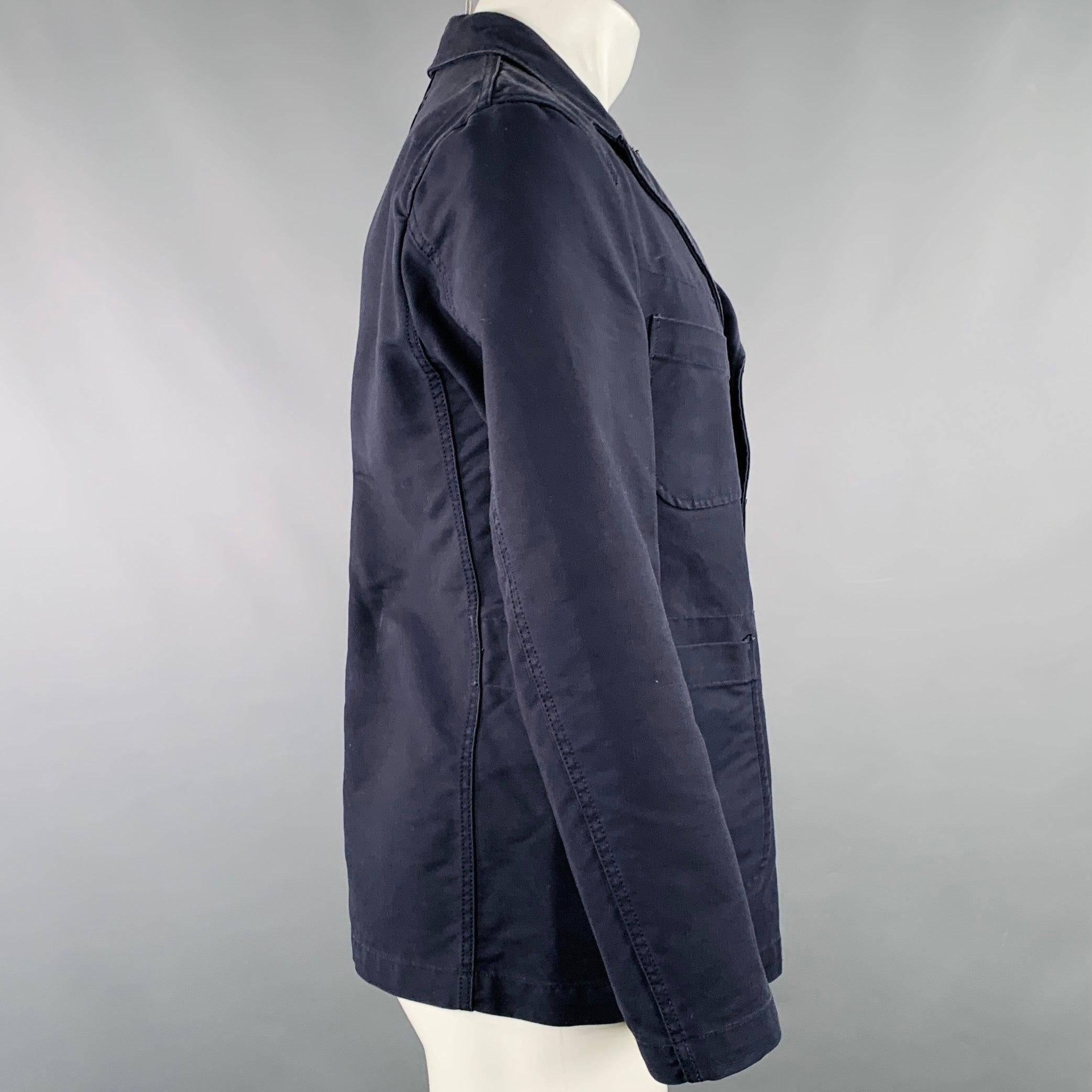 ENGINEERED GARMENTS jacket in a navy cotton woven fabric featuring a peak lapel, four pockets, and button closure. Made in USA.Very Good Pre-Owned Condition. Multiple marks. 

Marked:   S 

Measurements: 
 
Shoulder: 17.5 inches Chest: 39 inches