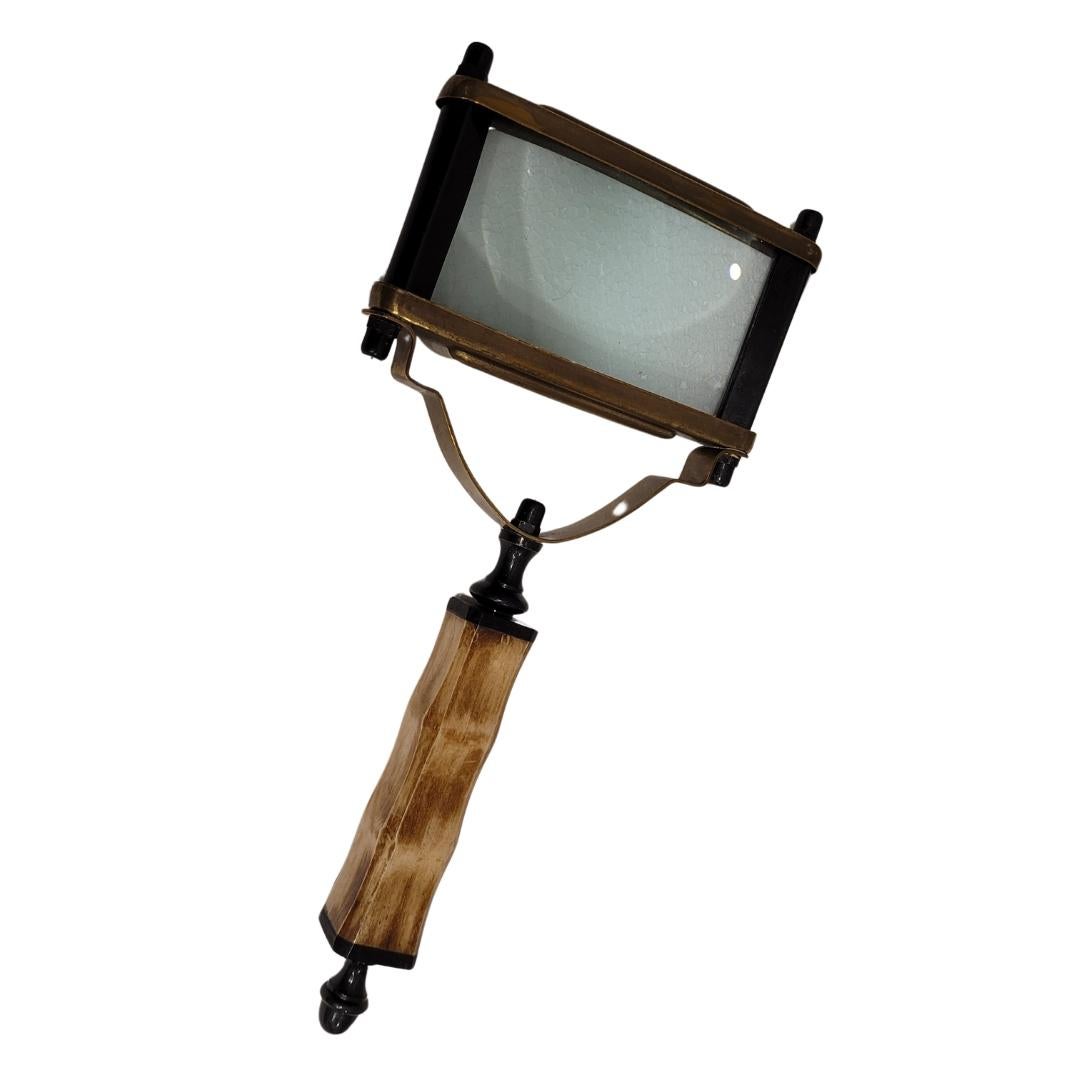 Extraordinary English magnifying glass made of metal, with a fabulous carved antler handle. It has a magnifying lens framed in a fine and elegant metal structure, with the originality of being a square-profile glass. The handle is made of antler, it
