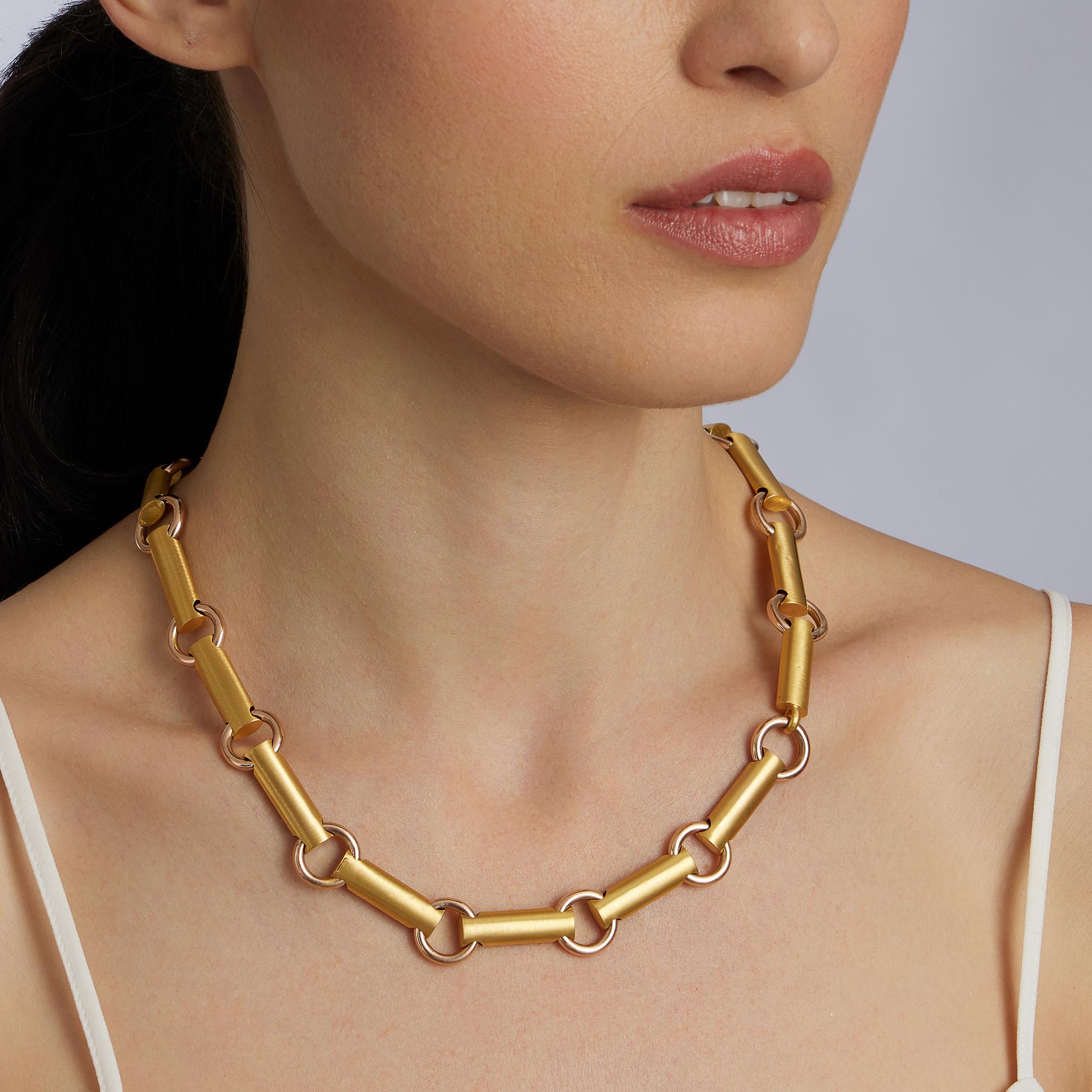 Made in England around 1880, this necklace is composed of bi-color 15K gold. The 20 inch geometric chain is composed of plain polished rose-gold circular links interspersed with brushed yellow gold cylindrical bar links. Light and supremely