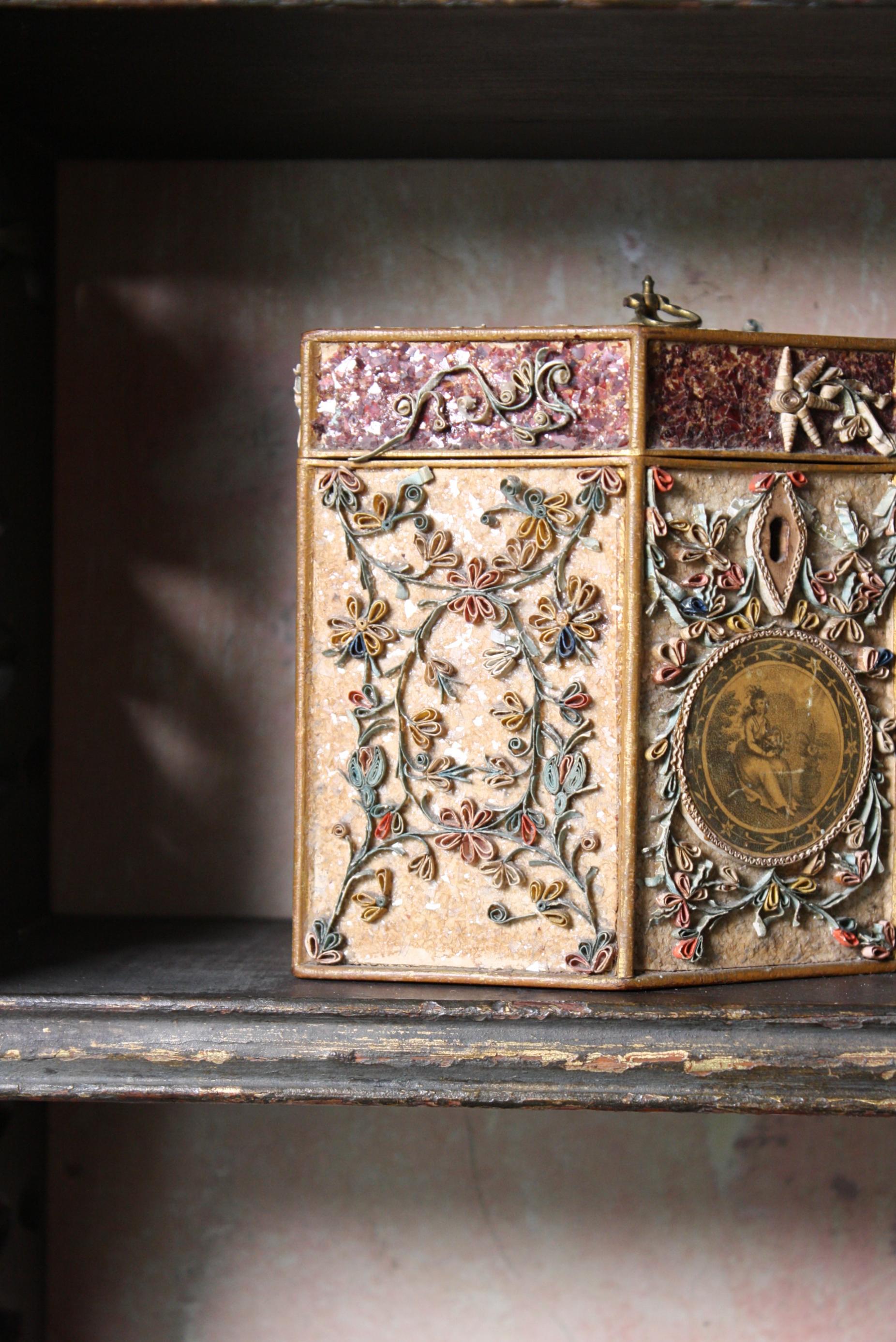 A wonderful 18th century George III quill work (scrollwork) tea caddy of elongated hexagon form. 

English circa 1790

Decorated with floral panels and a painting roundel of a young lady holding a basket of flowers, monogram to the reverse