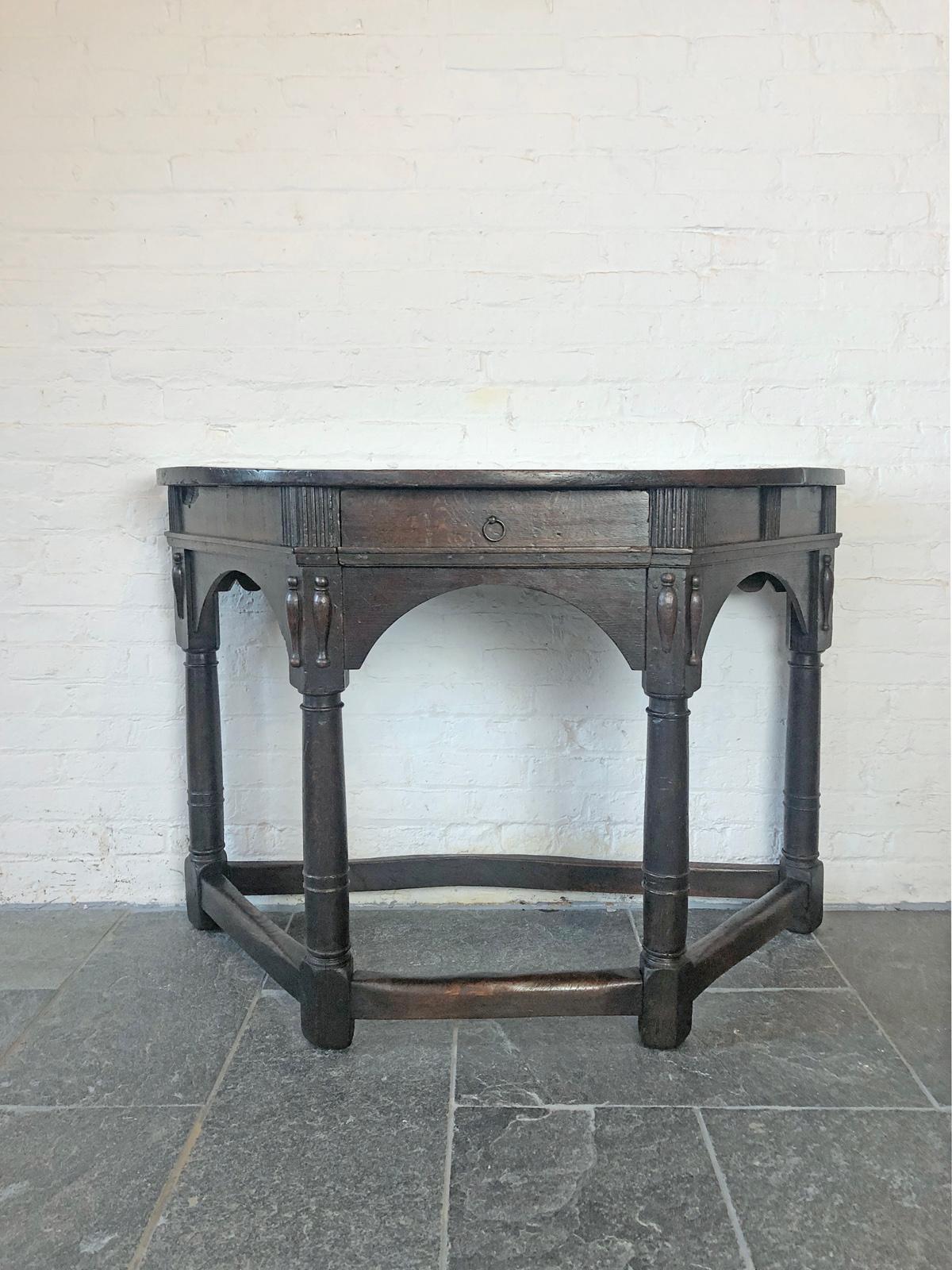 Maravillosa e intemporal mesa consola Demi-Lune inglesa de roble, fabricada hacia 1630 durante el reinado de Carlos I, que muestra una gran pátina y encantadores signos de uso y antigüedad. La parte superior, en forma de demi-luna, sobre un friso