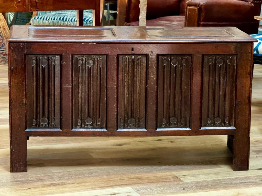 An English 17th Century joined oak linen-fold coffer, the chest with a paneled hinged top above a carved linen-fold paneled front and sides.  Having a beautiful patina and in excellent condition.  Particularly lovely version of this form, ex.