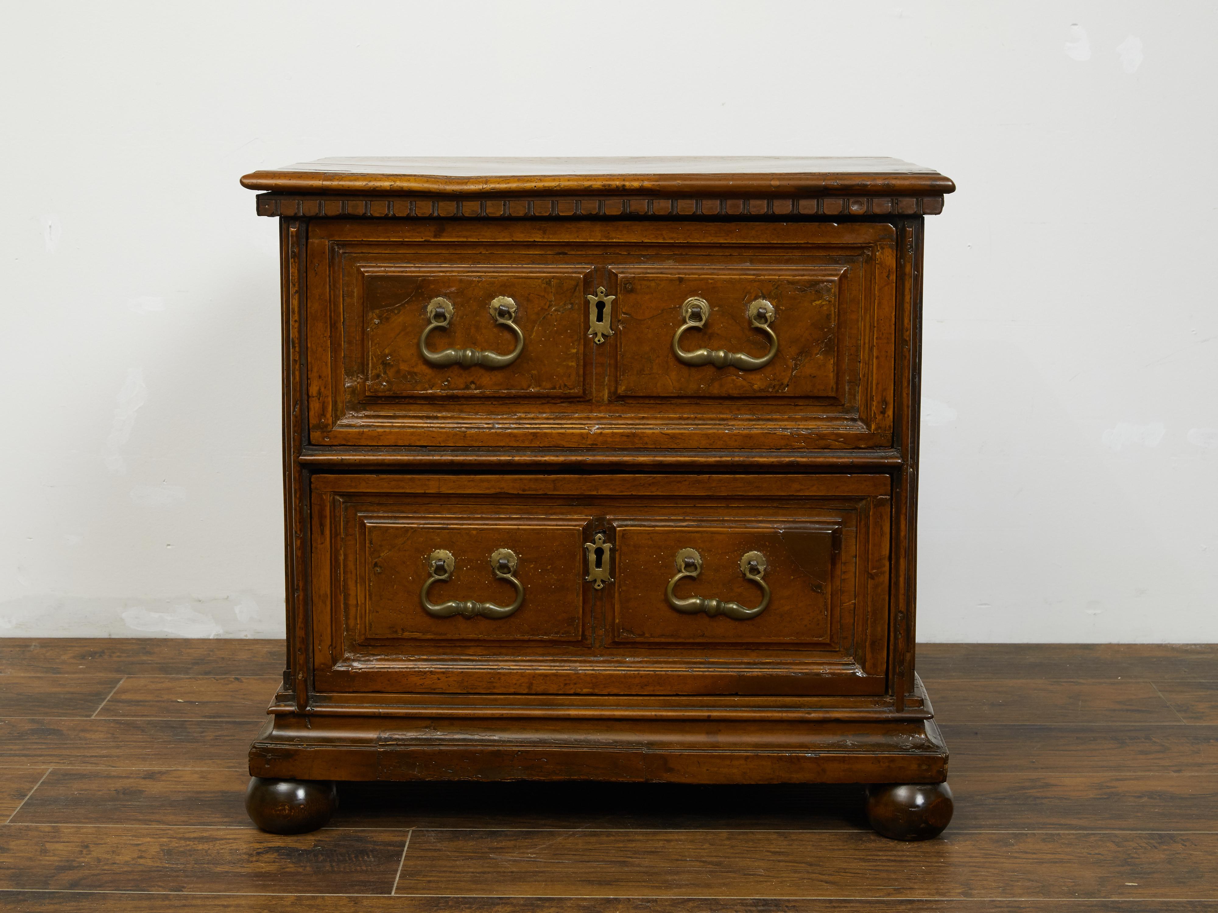 An English walnut commode from the early 19th century, with dentil molding and two drawers. Created in England during the early years of the 19th century, this petite walnut commode features a rectangular top sitting above a dentil molding. The rest