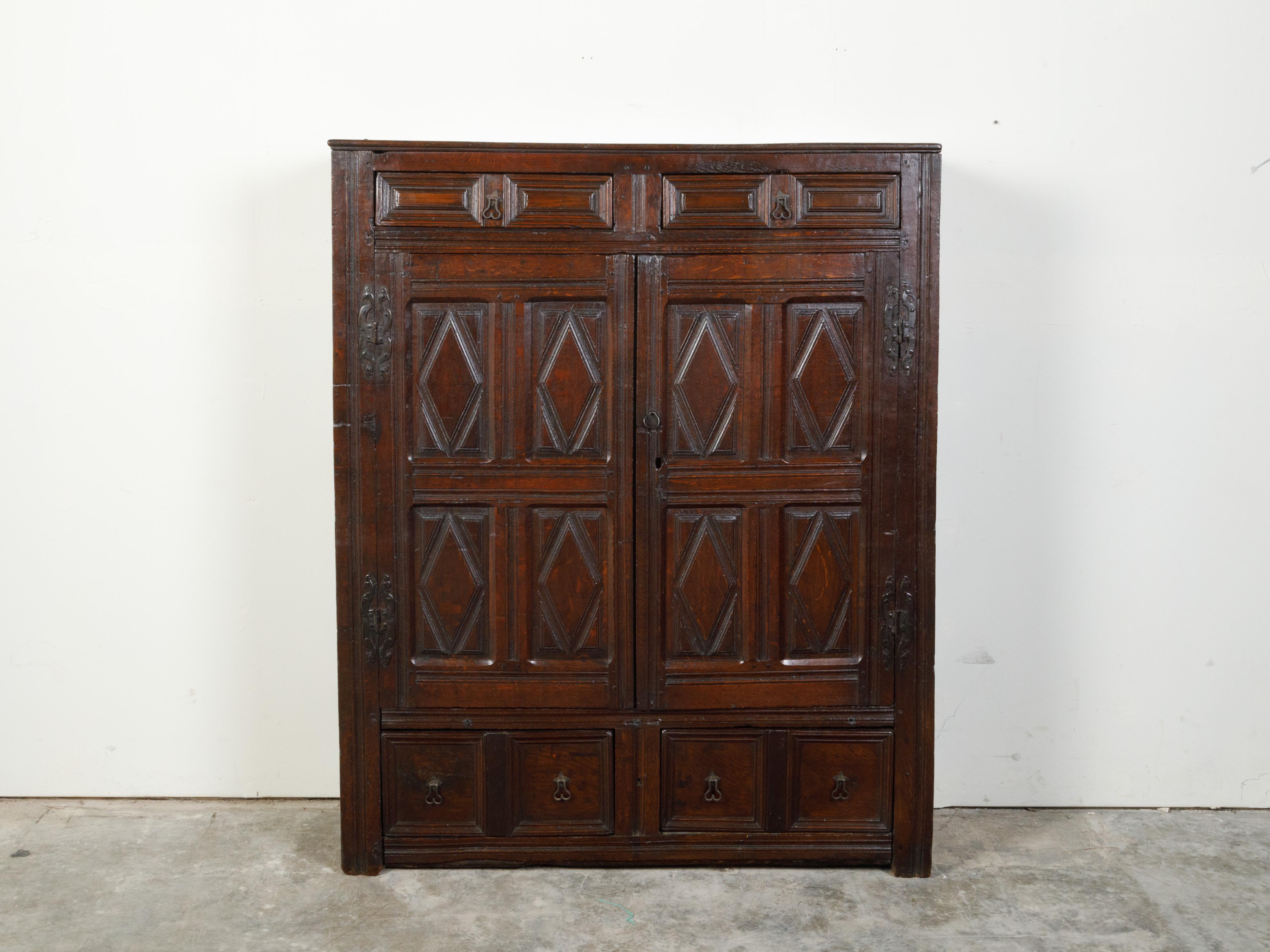 Ein englischer Hofschrank aus Holz aus dem frühen 19. Jahrhundert, mit Rautenmotiven, Türen und Schubladen. Dieser Hofschrank, der im 19. Jahrhundert in England hergestellt wurde, hat eine rechteckige Platte, die über zwei Schubladen mit leicht