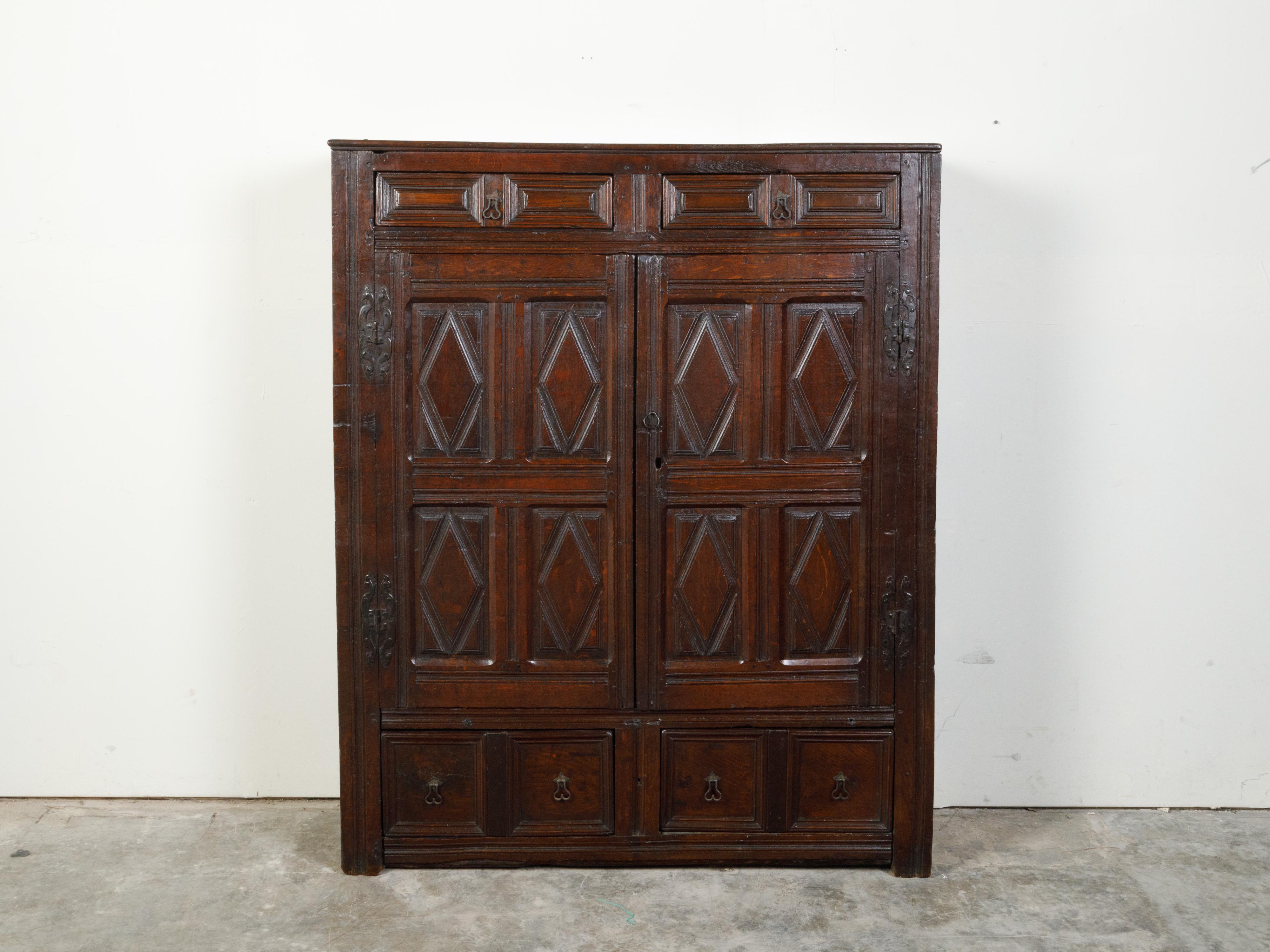 An English wooden court cupboard from the early 19th century, with diamond motifs, doors and drawers. Created in England during the 19th century, this court cupboard features a rectangular top sitting above two drawers with slightly raised panels