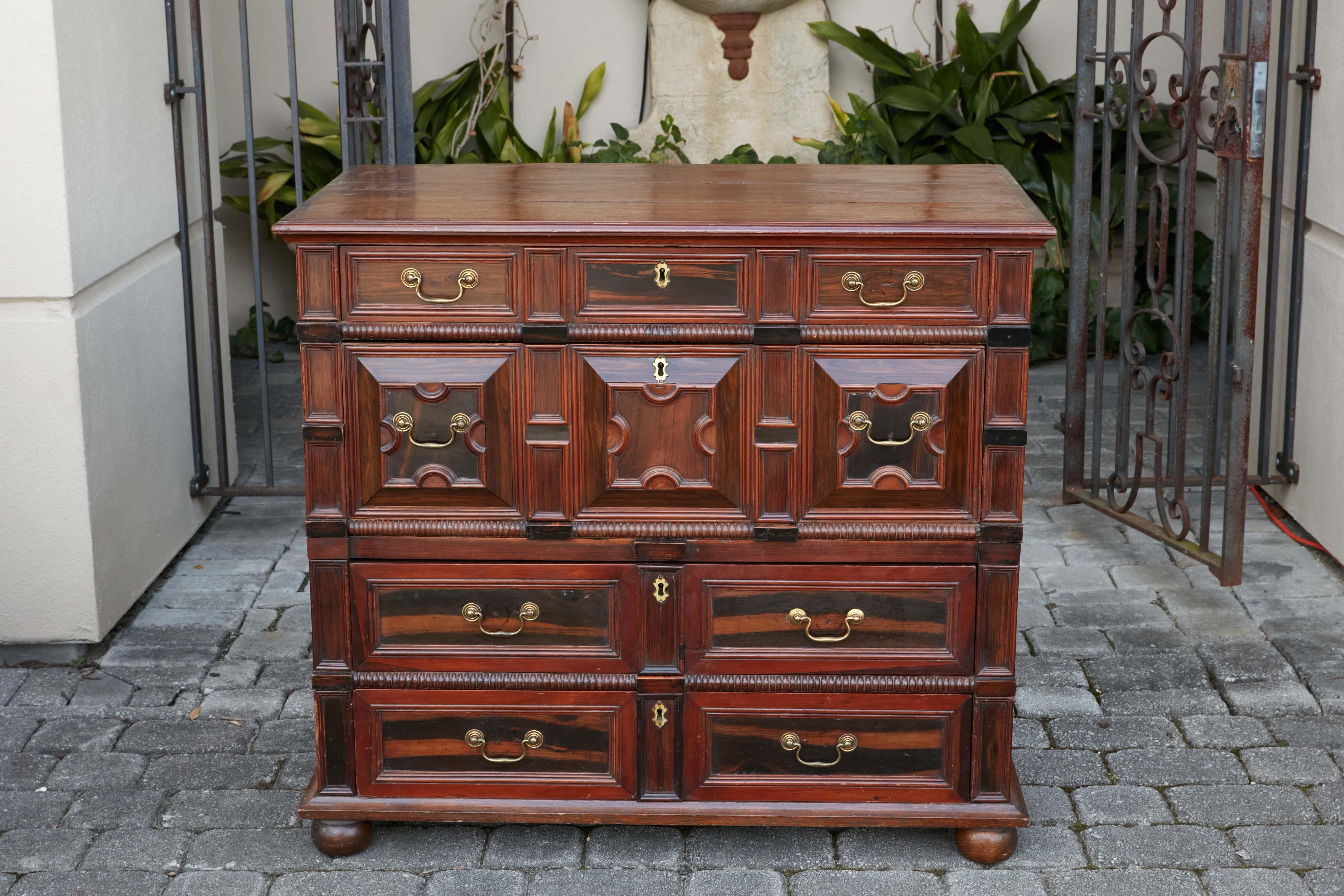 An English Georgian period geometric front four-drawer chest from the early 19th century, made of mahogany, oak and macassar ebony. Created in England during the first quarter of the 19th century, this Georgian chest features a rectangular planked