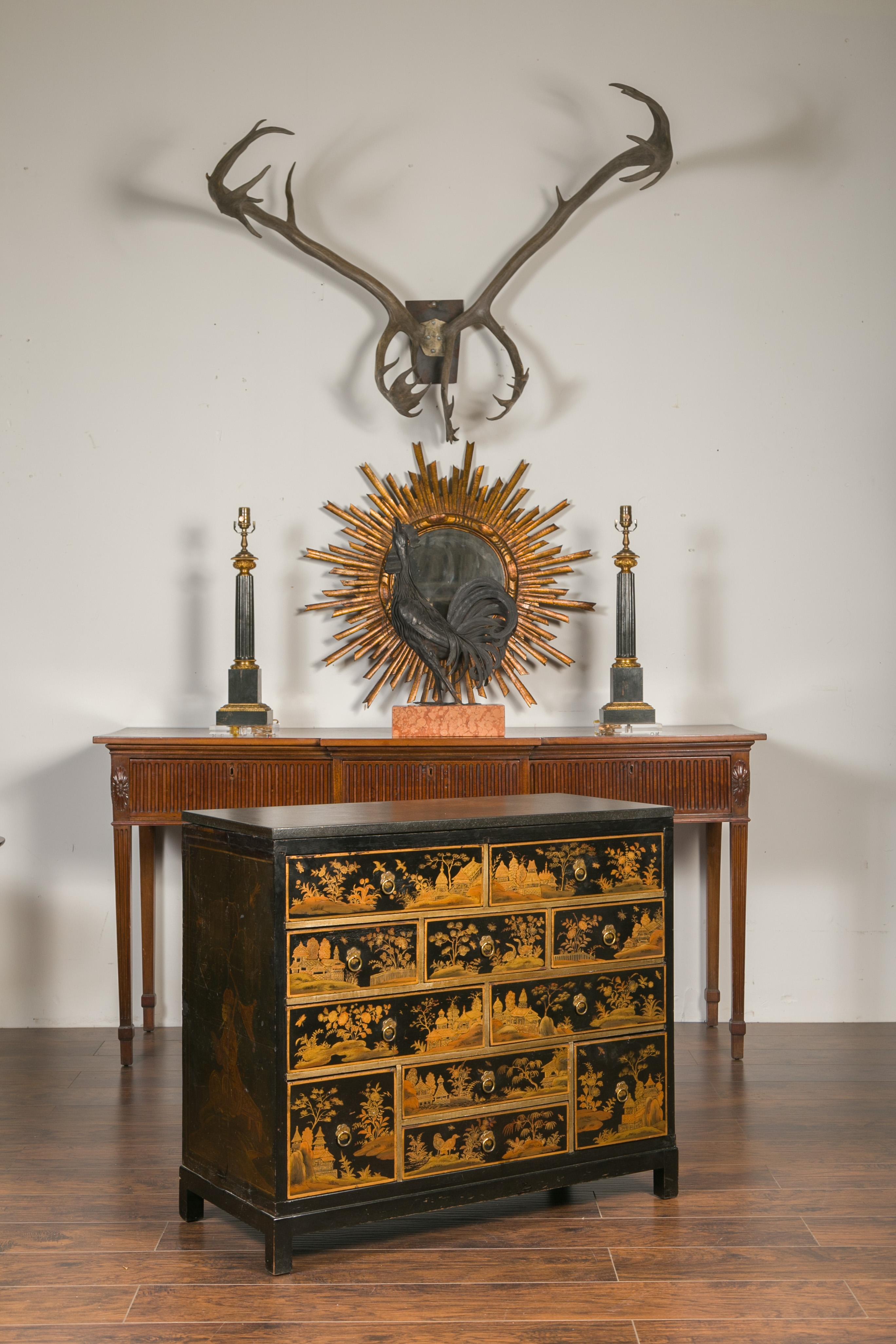 An English Georgian ebonized chinoiserie chest-of-drawers from the early 19th century with gilt and black lacquered accents and later added stone top. Created in England during the first quarter of the 19th century, this chest attracts our immediate