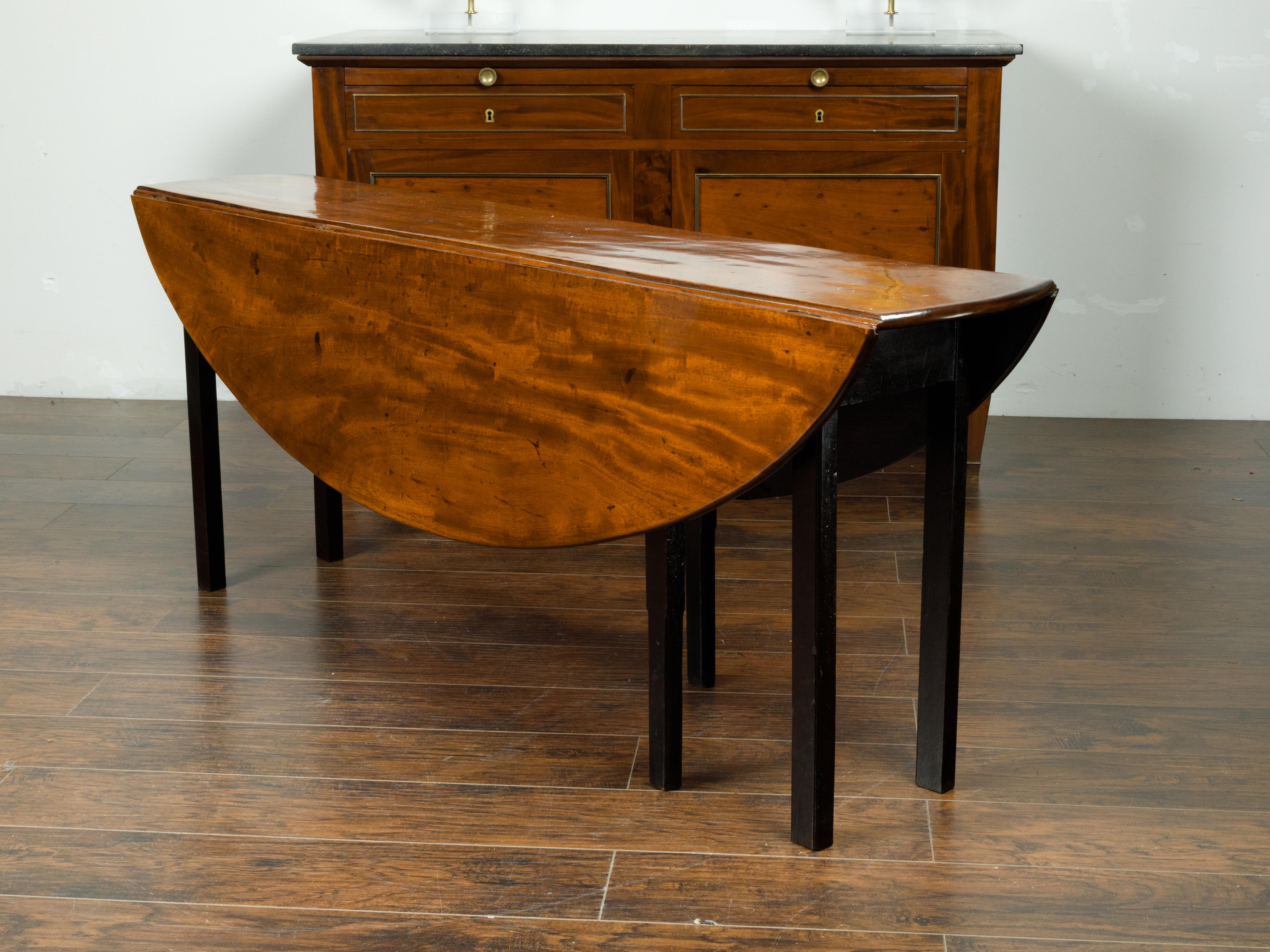 English 1820s Mahogany Drop Leaf Dining Table with Oval Top and Ebonized Legs 5