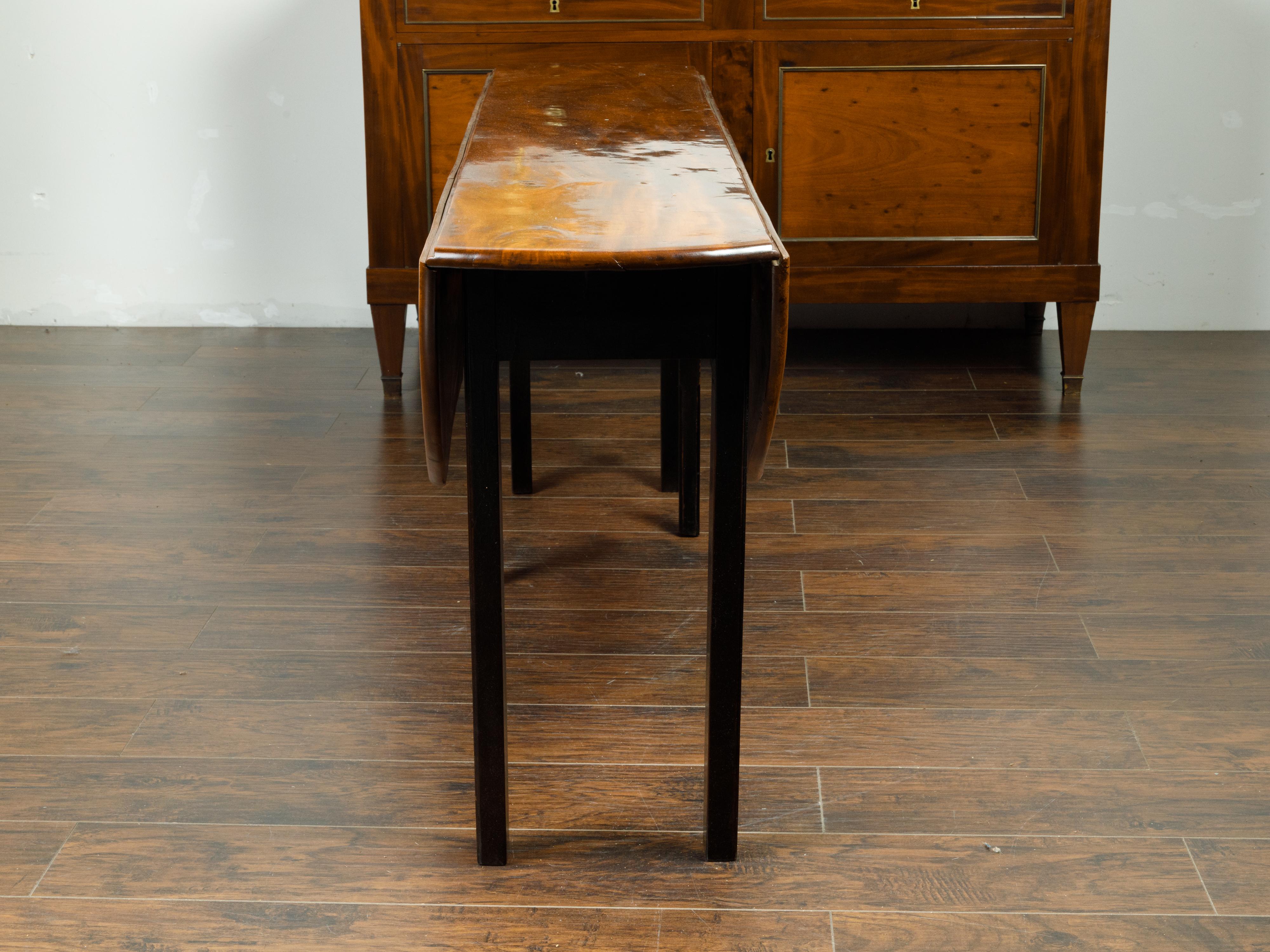 English 1820s Mahogany Drop Leaf Dining Table with Oval Top and Ebonized Legs 6