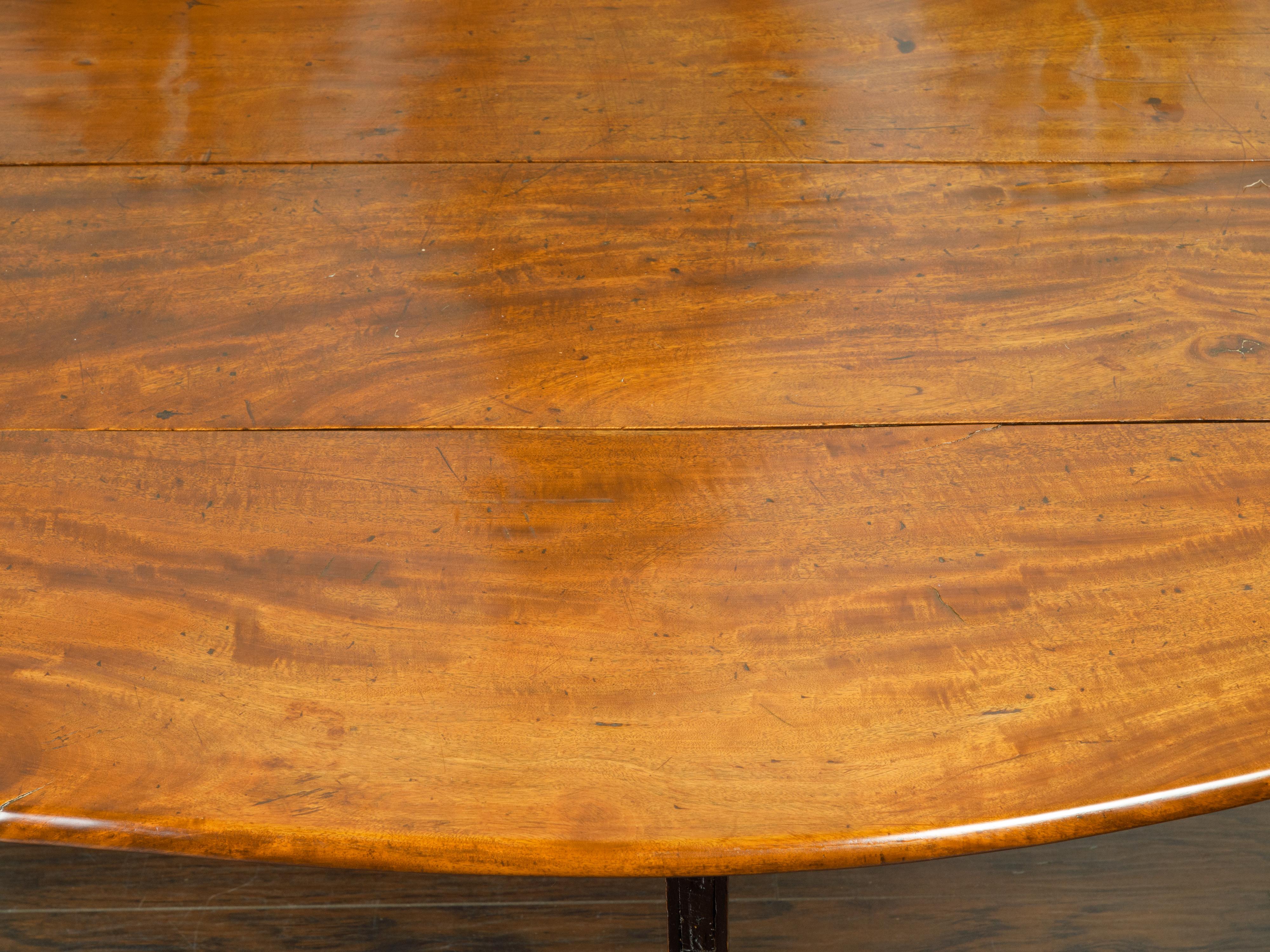 Wood English 1820s Mahogany Drop Leaf Dining Table with Oval Top and Ebonized Legs