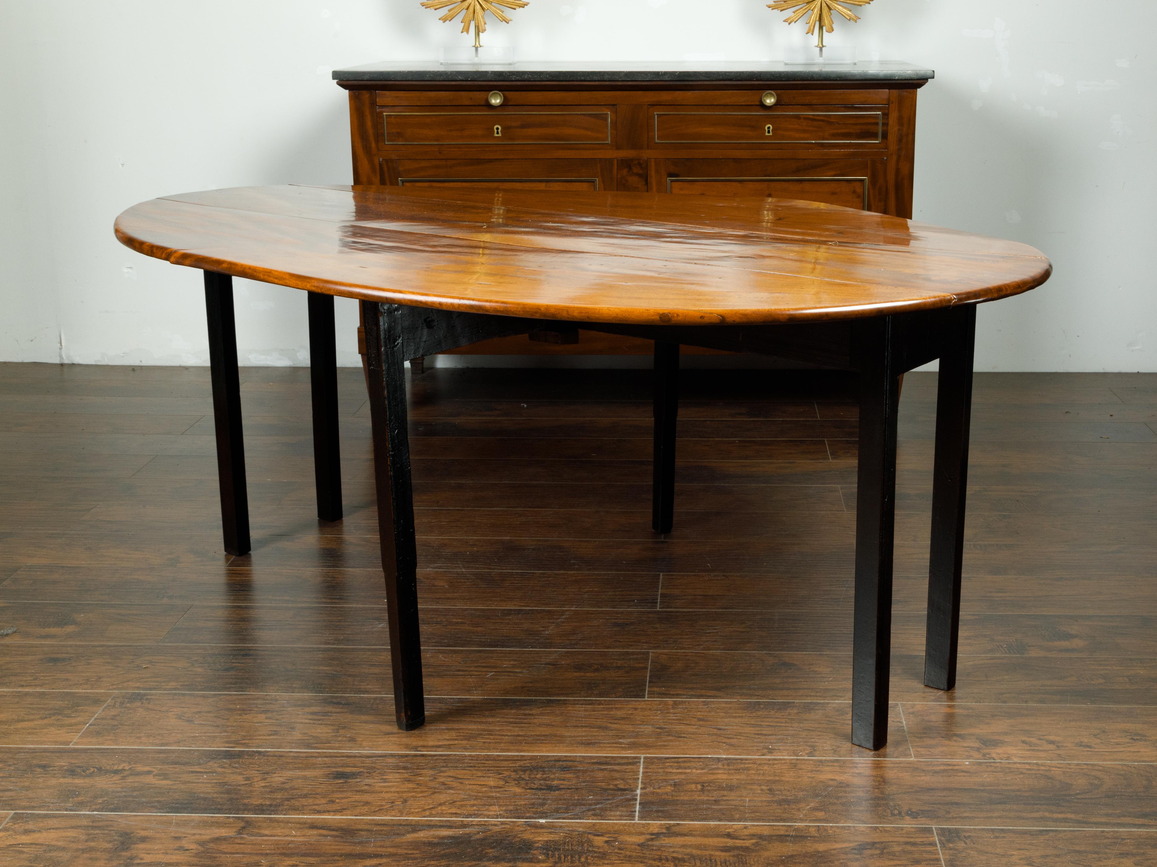 English 1820s Mahogany Drop Leaf Dining Table with Oval Top and Ebonized Legs 1
