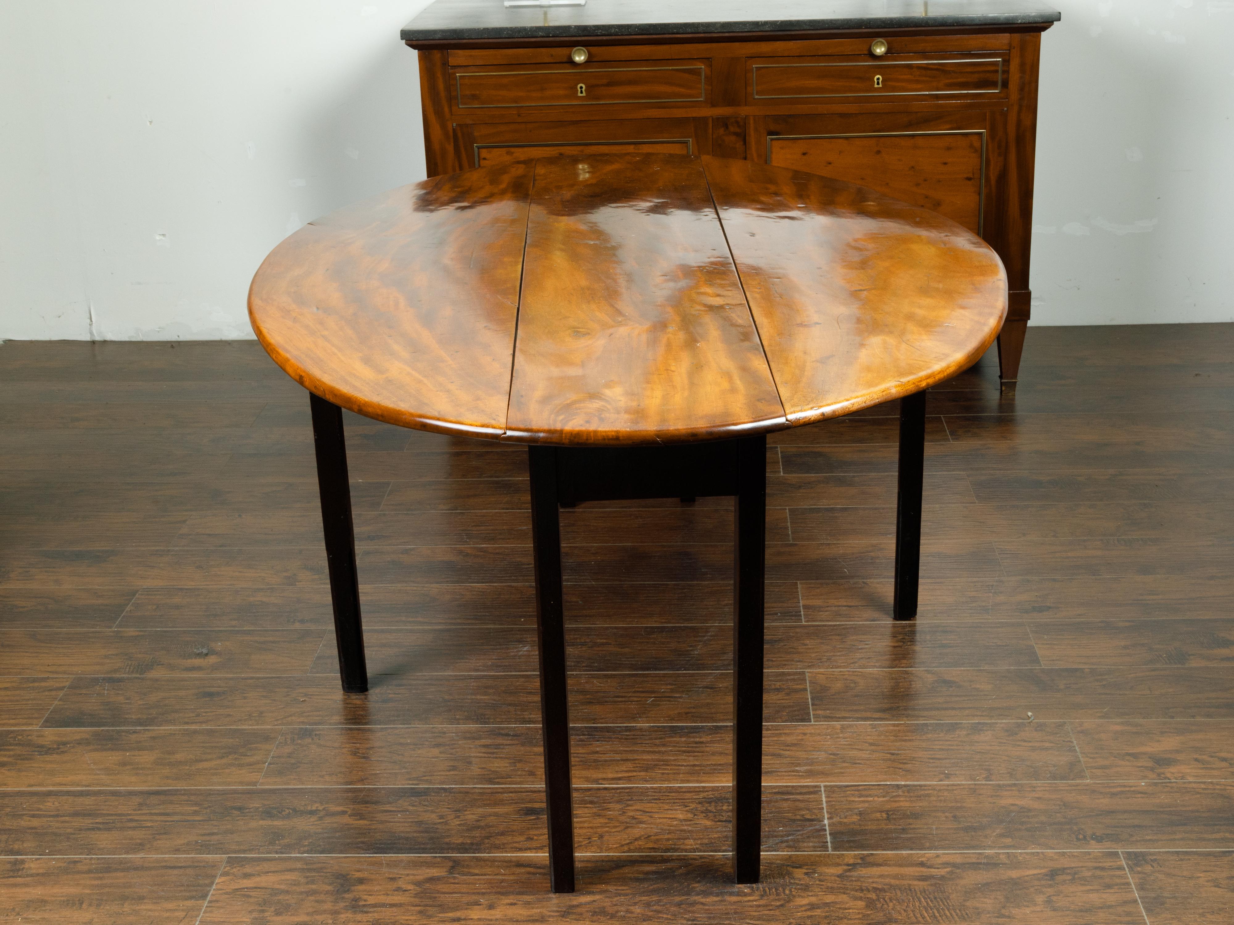 English 1820s Mahogany Drop Leaf Dining Table with Oval Top and Ebonized Legs 2
