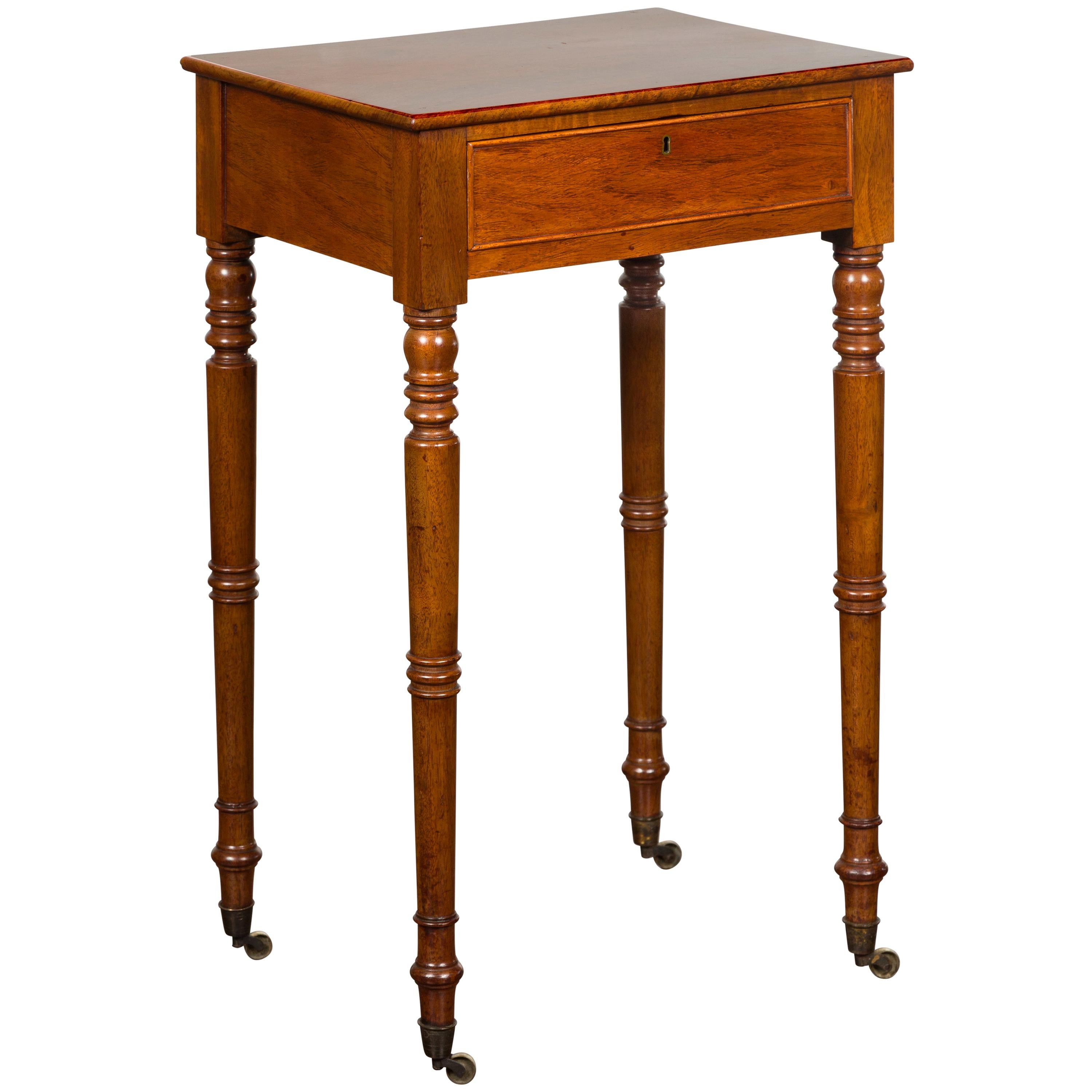 English 1820s Walnut Side Table with Single Drawer, Turned Legs and Casters For Sale