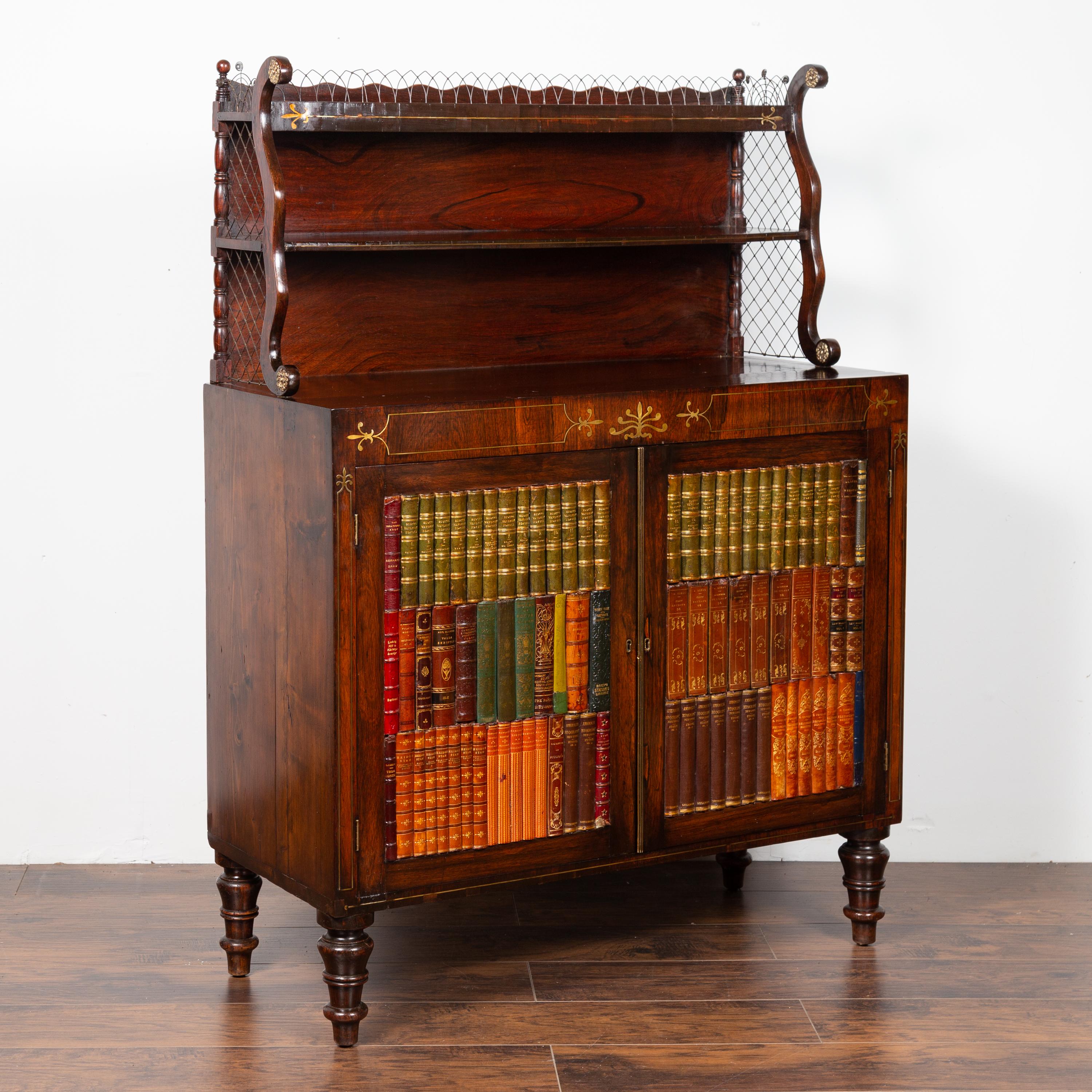 An English mahogany cabinet from the mid-19th century, with faux-book doors and open upper shelf. Born in England during the first half of the 19th century, this handsome cabinet features an open shelf, accented with scrolled supports and chicken