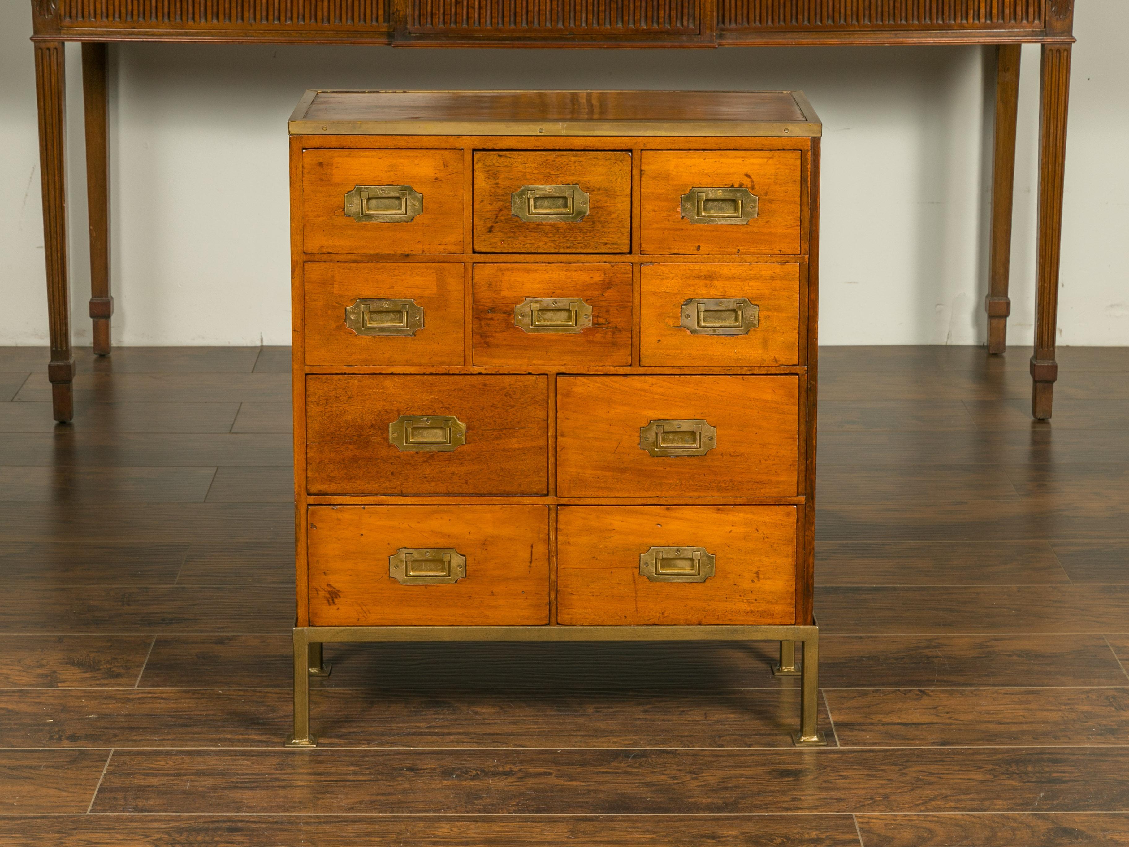 An English mahogany and pine Campaign chest from the mid-19th century, with brass accents and new custom gilt iron stand. Created in England during the second quarter of the 19th century, this Campaign chest features a rectangular top surrounded by