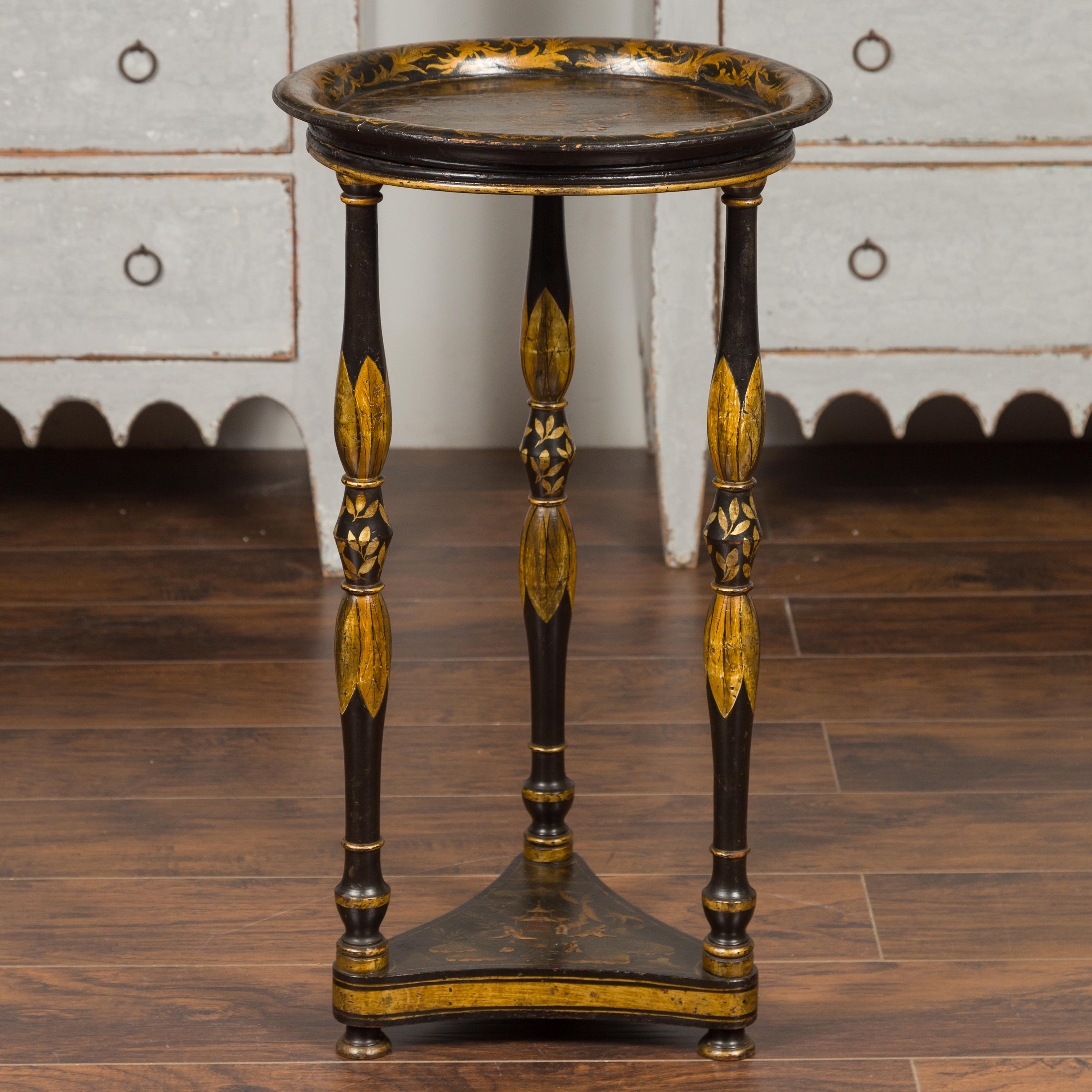 An English chinoiserie guéridon table from the mid-19th century, with traditional scenery, turned legs and lower shelf. Born in England during the 1850s, this guéridon table features a circular tray top resting on three delicately turned legs