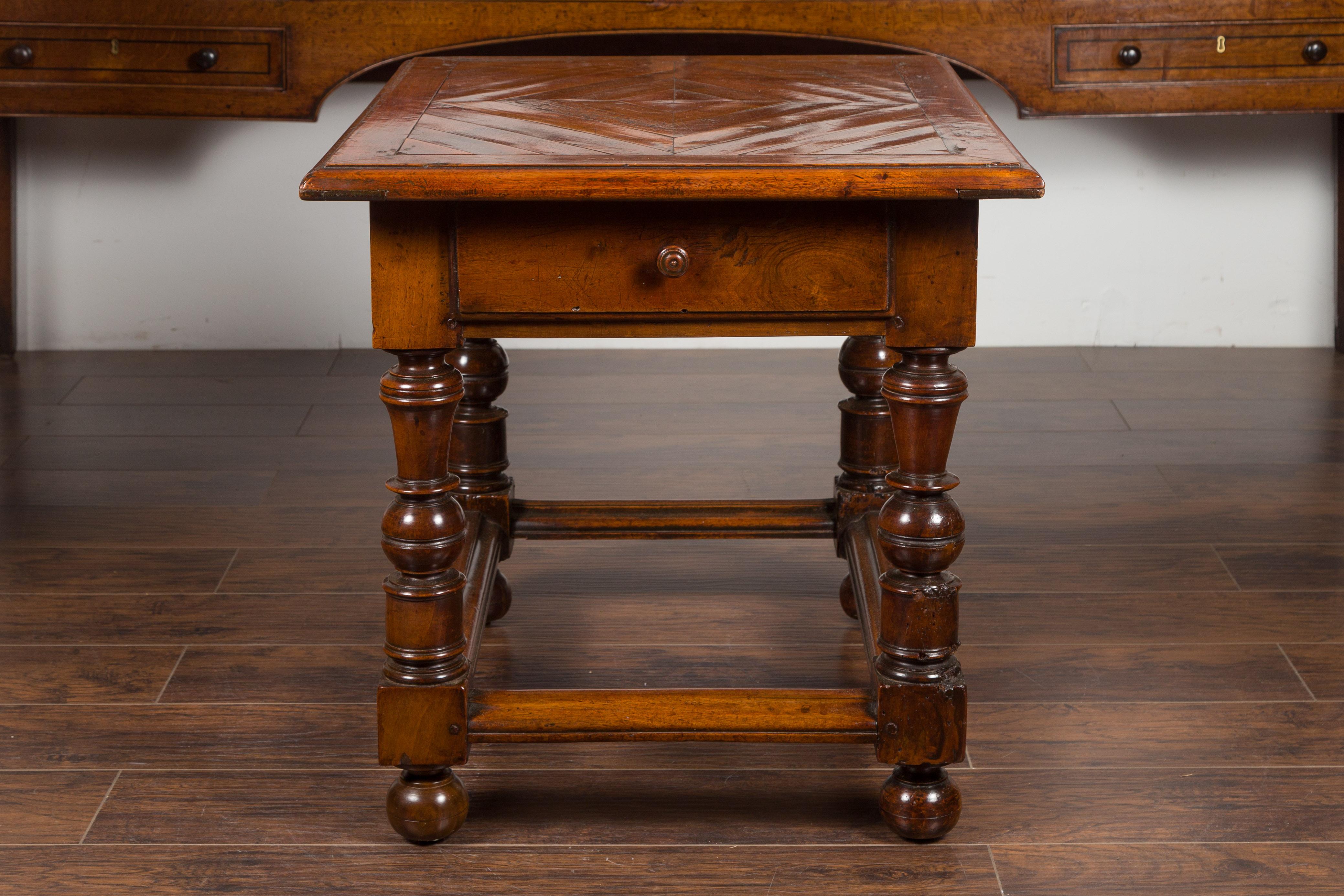 An English walnut parquet top table from the mid-19th century, with single drawer and turned legs. Created in England during the 1850s, this walnut table features an exquisite parquet inlaid rectangular top, sitting above a single drawer fitted with