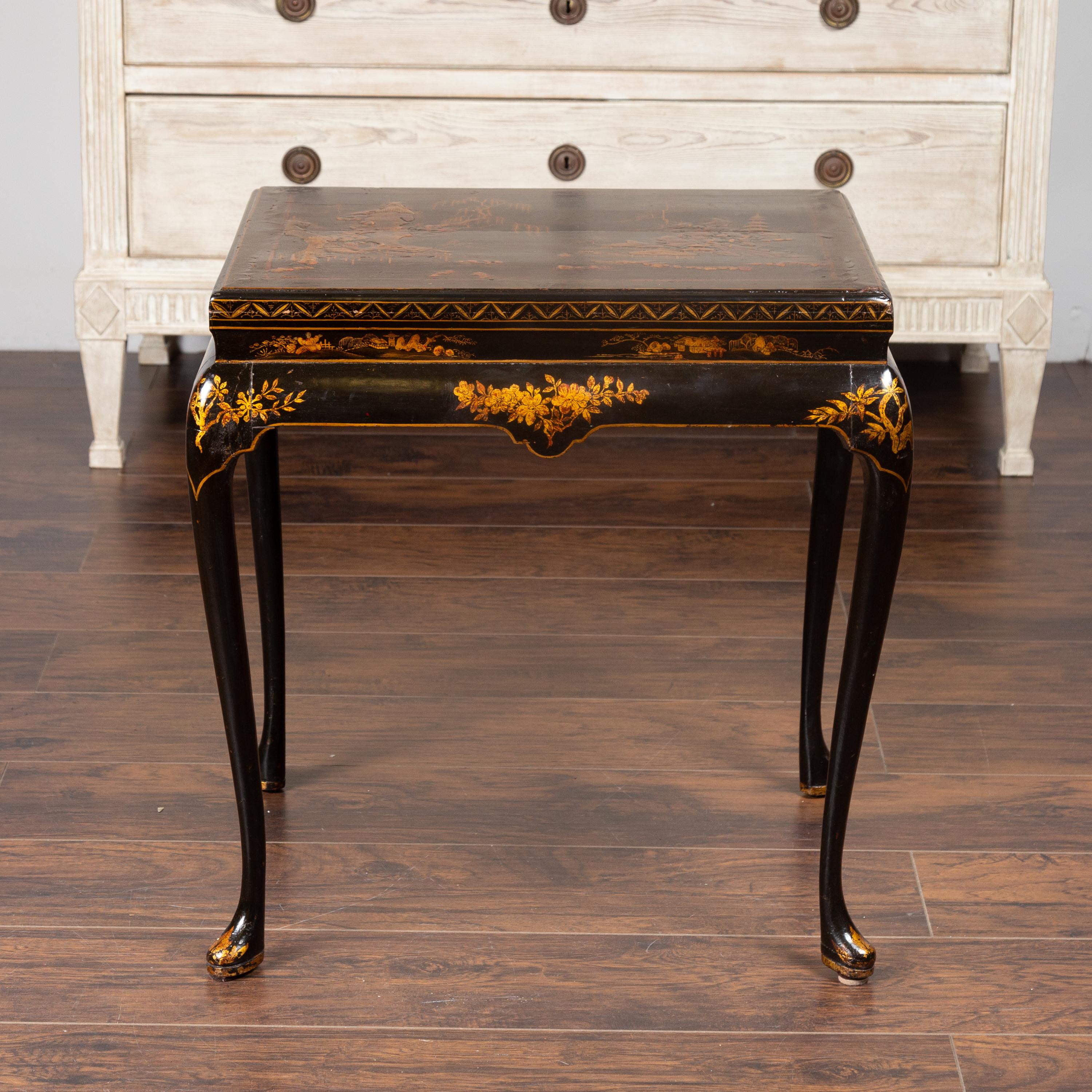 An English black lacquered side table from the mid-19th century, with gilded chinoiserie décor and cabriole legs. Born in England during the third quarter of the 19th century, this exquisite side table presents a lovely contrast of colors between