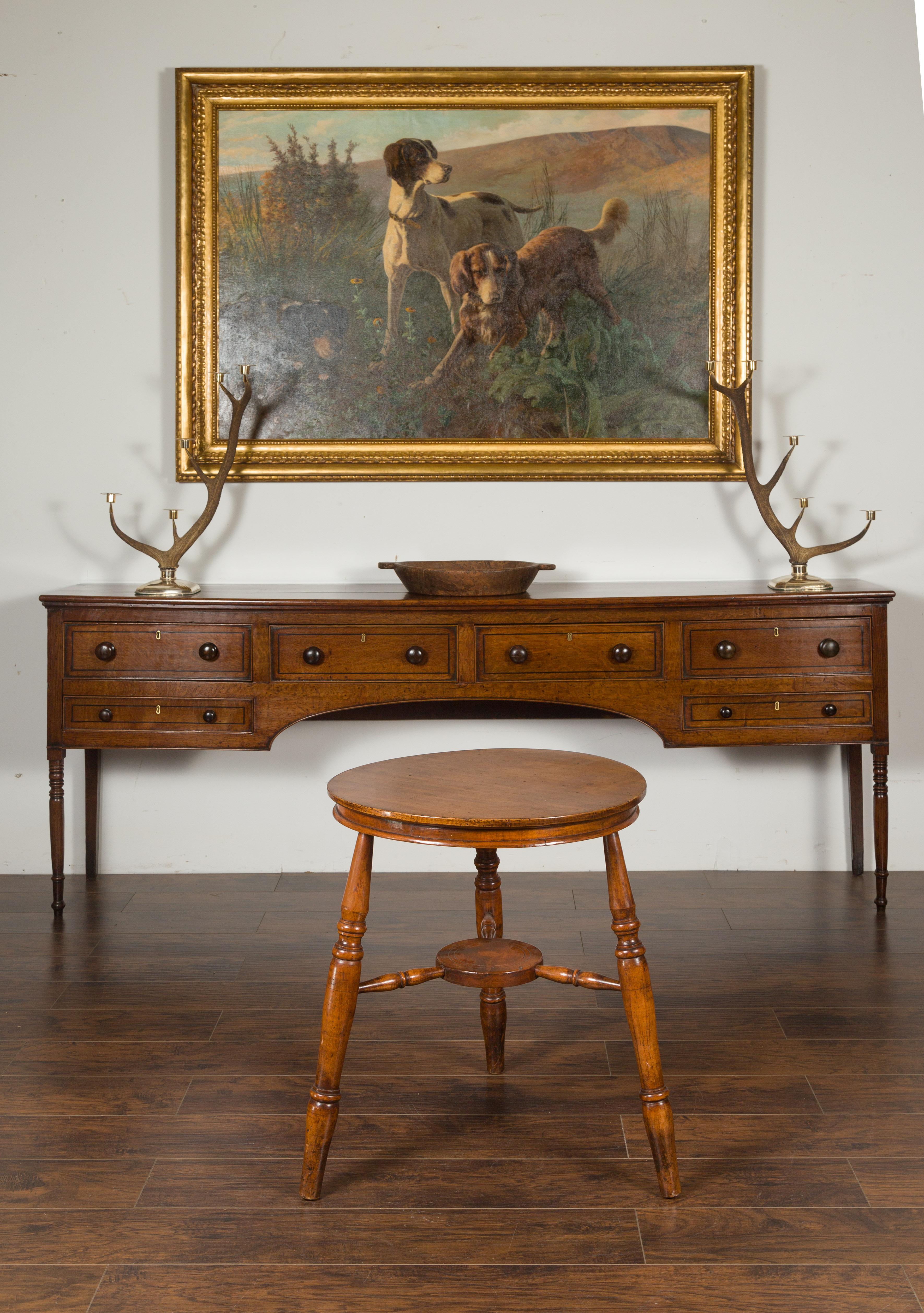An unusual English cricket table from the mid-19th century, with circular sycamore top and cross-stretcher. Born in England during the third quarter of the 19th century, this cricket table features a round sycamore top, sitting above three turned