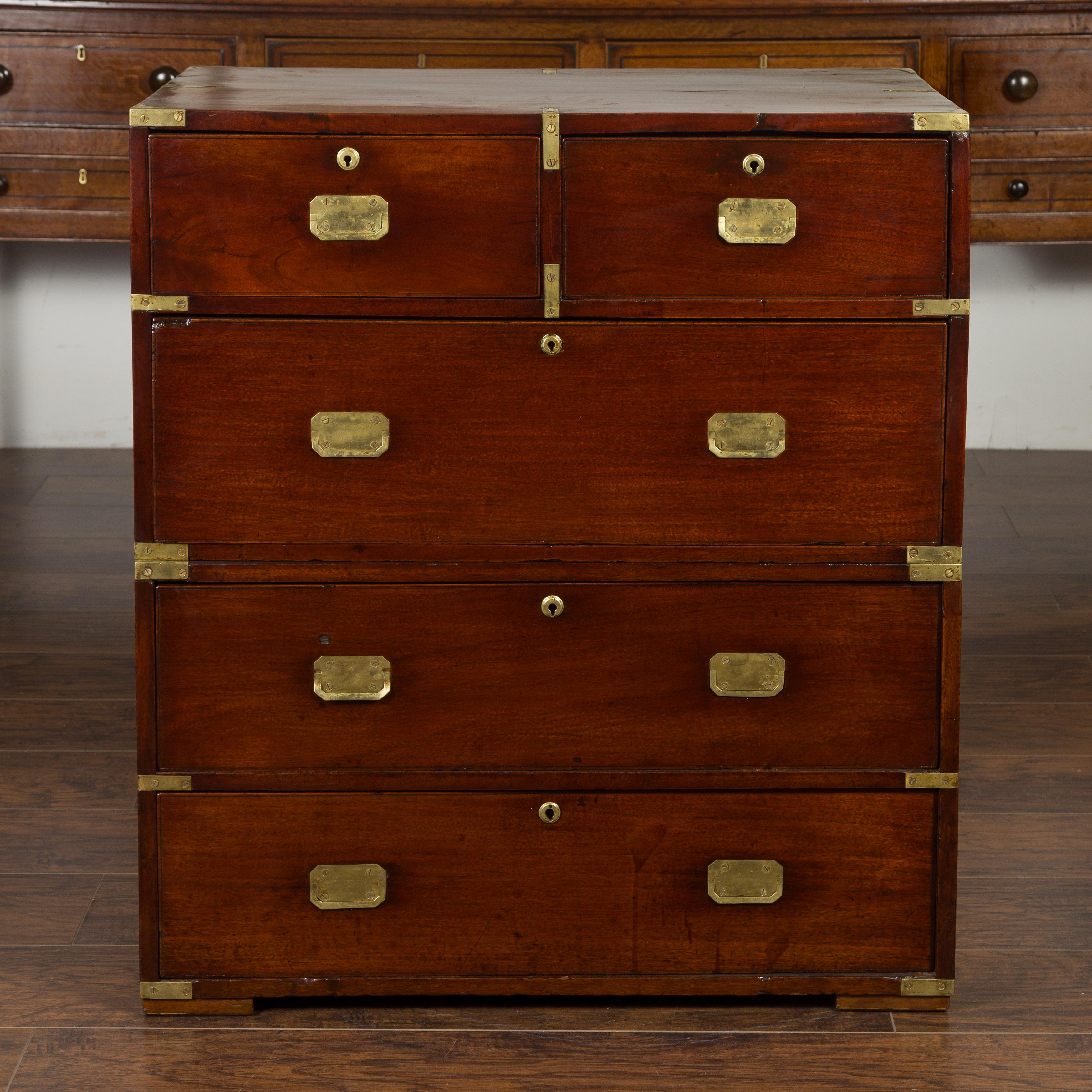 An English mahogany campaign chest from the mid-19th century, with small desk area and brass accents. Created in England during the third quarter of the 19th century, this mahogany campaign chest features a rectangular top sitting above five drawers