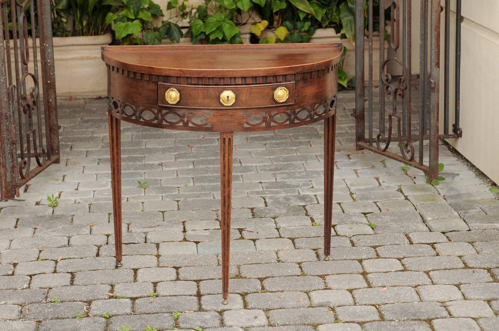 An English oak demilune console table from the mid-19th century, with tray top, single drawer and tapered legs. Born in England during the third quarter of the 19th century, this oak demilune console table captivates with its elegant design and
