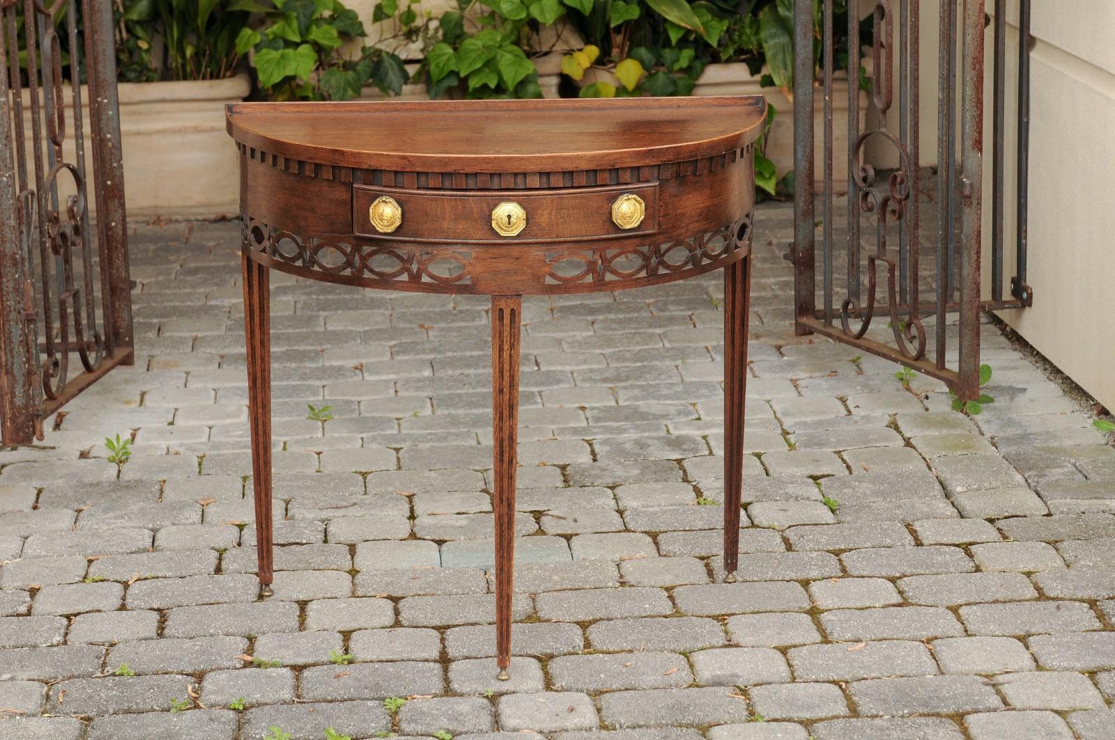 An English oak demilune console table from the mid-19th century, with tray top, single drawer and tapered legs. Born in England during the third quarter of the 19th century, this oak demilune features a semi-circular tray top, sitting above an