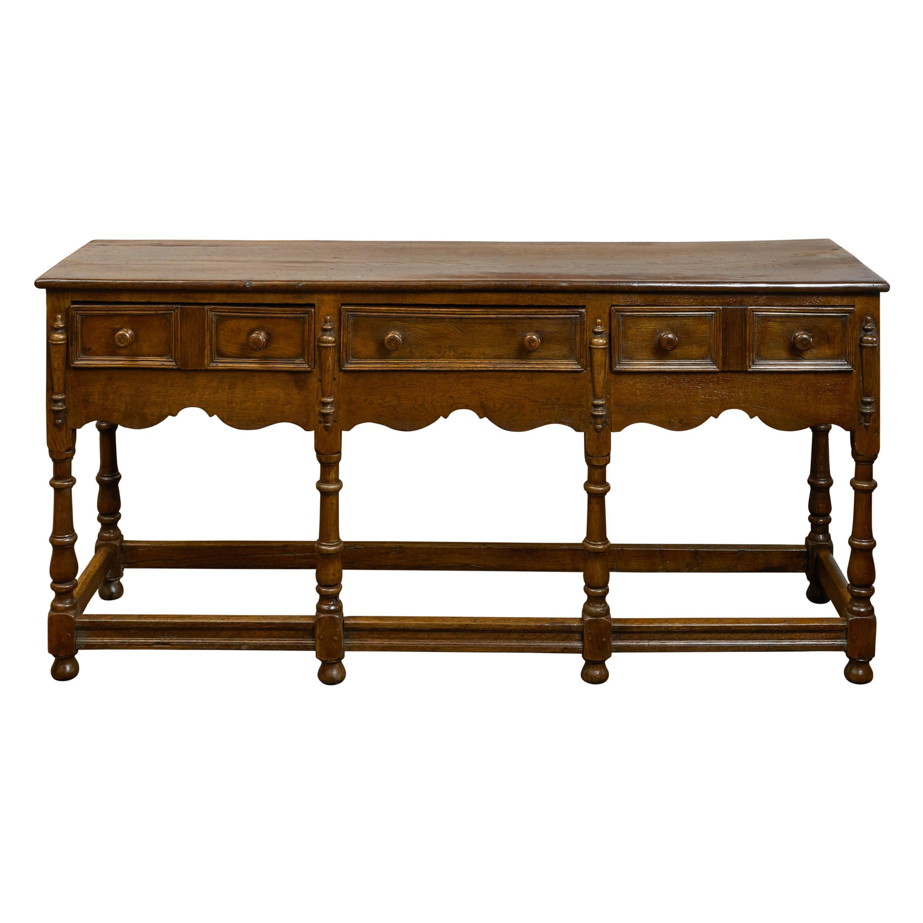 English 1860s Oak Dresser Base with Drawers, Scalloped Apron and Turned Legs For Sale