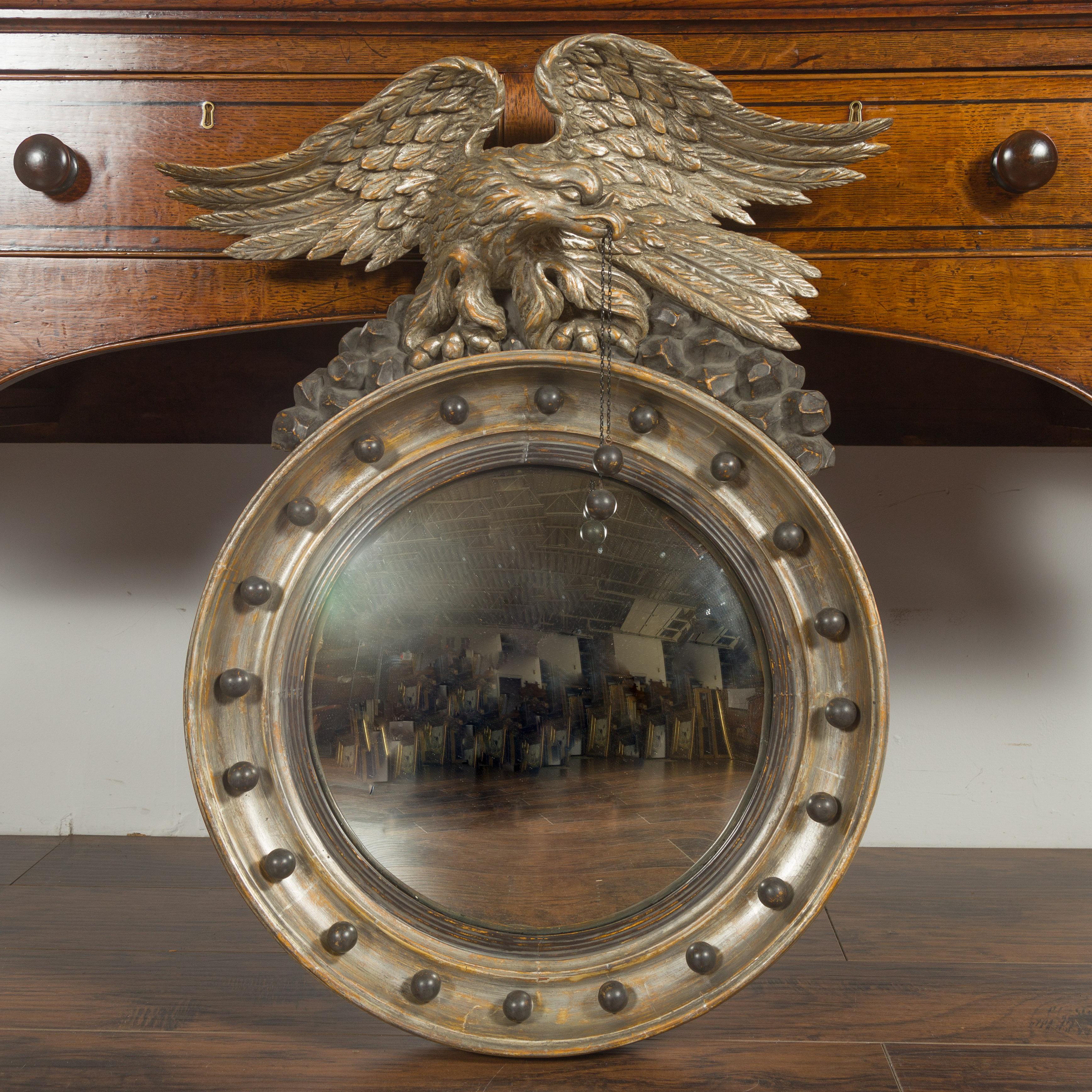 An English silver leaf convex girandole bullseye mirror from the mid-19th century, with eagle motif. Created in England during the third quarter of the 19th century, this silver leaf girandole mirror attracts our attention with its majestic eagle